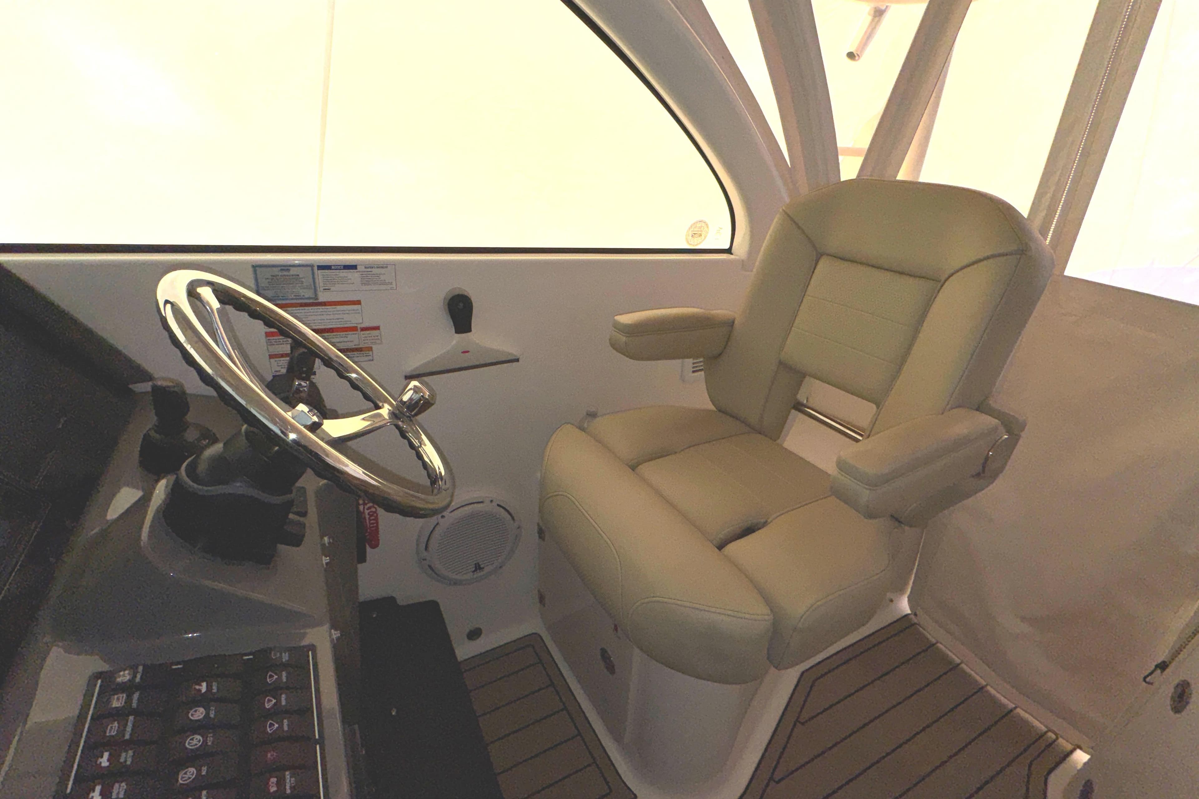 2019 Pursuit OS 385 Offshore helm with steering wheel and captain's chair.