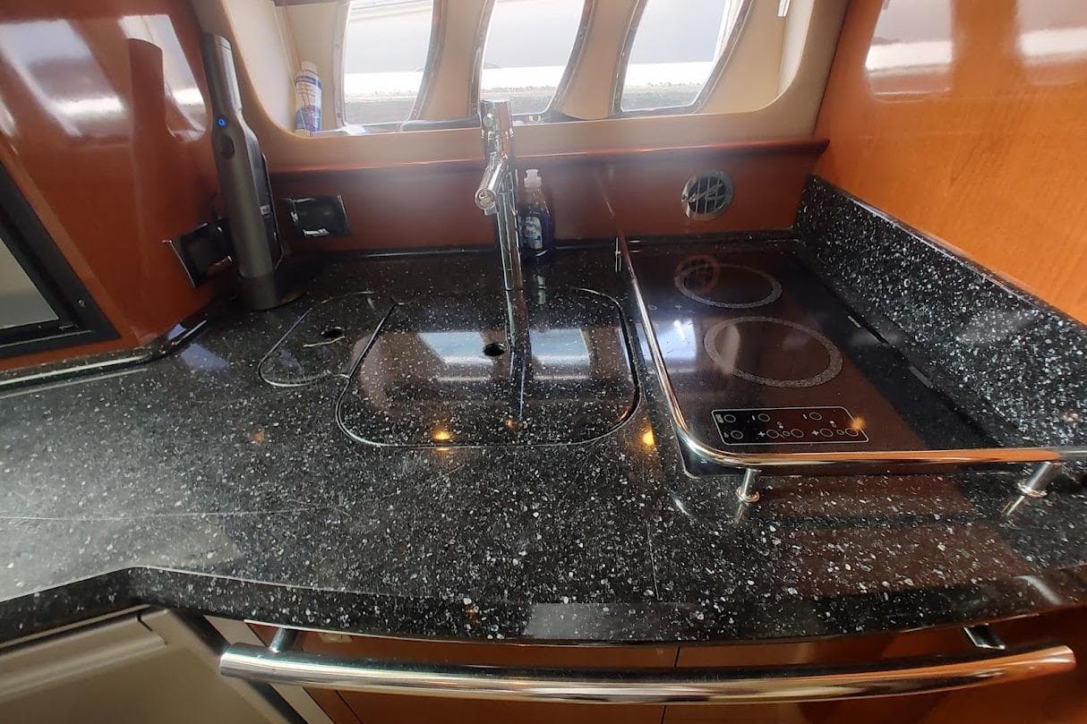Luxurious galley kitchen in 2009 Sea Ray 380 Sundancer yacht with sleek countertops.