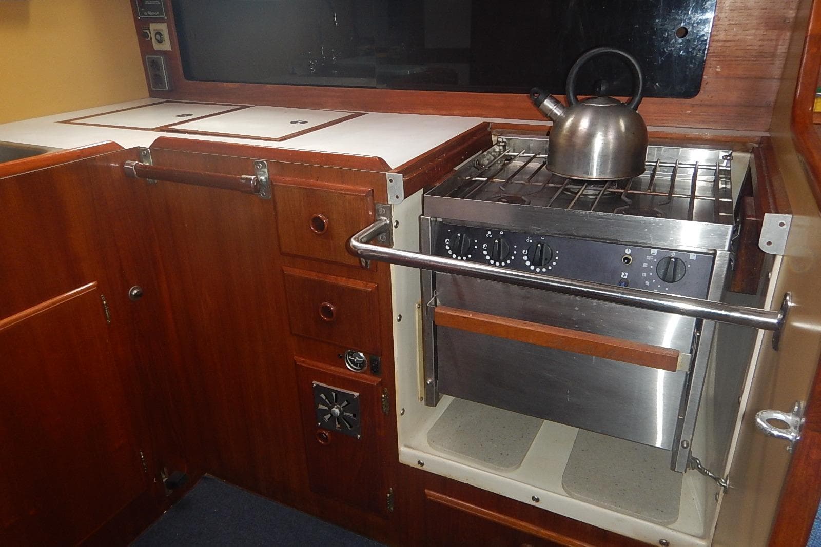 1978 Pearson 424 yacht galley with stove, kettle, and wooden cabinetry.