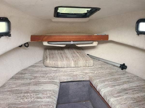 1994 Bayliner Trophy cabin interior with cushioned seating and overhead storage.