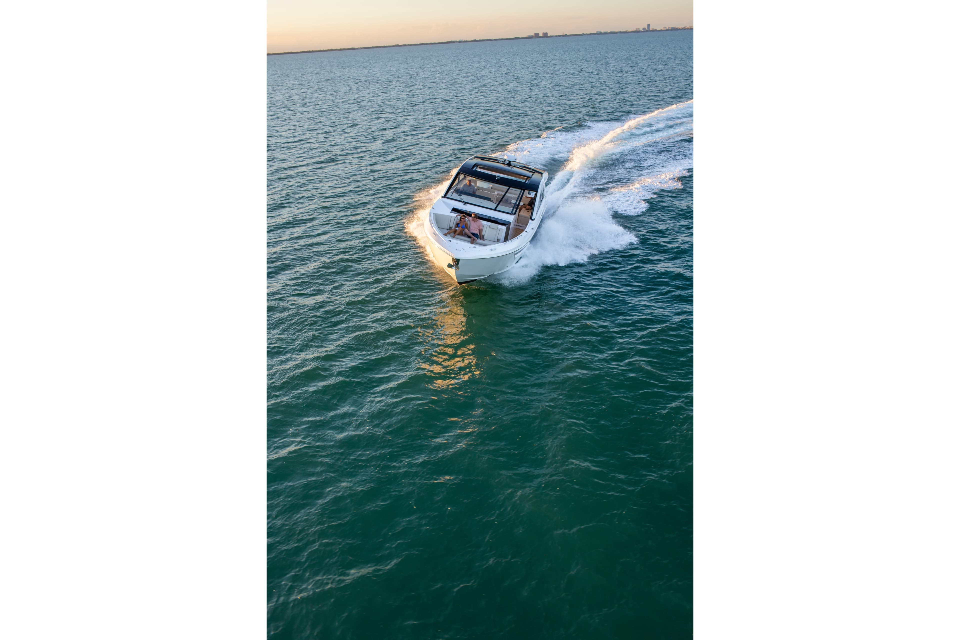 2026 Cruisers Yachts 50 GLS cruising on open water at sunset.