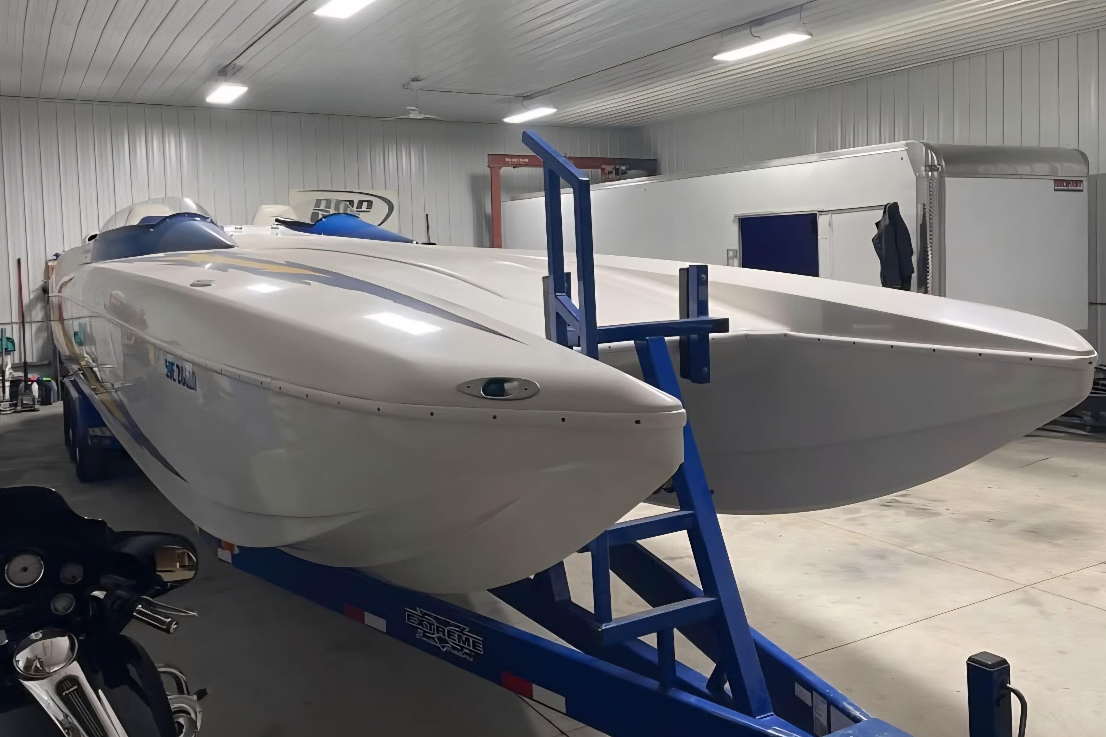 2001 Eliminator 36 Daytona powerboat on trailer in a well-lit garage.