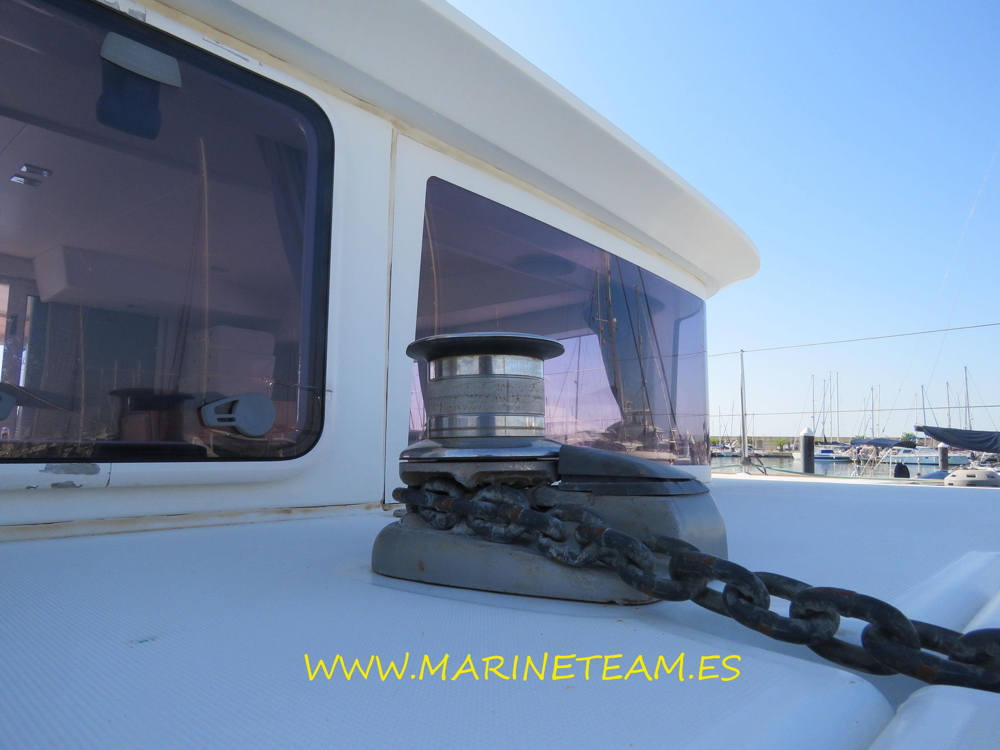 2015 Lagoon 400 S2 yacht with anchor chain on deck, marina in background.