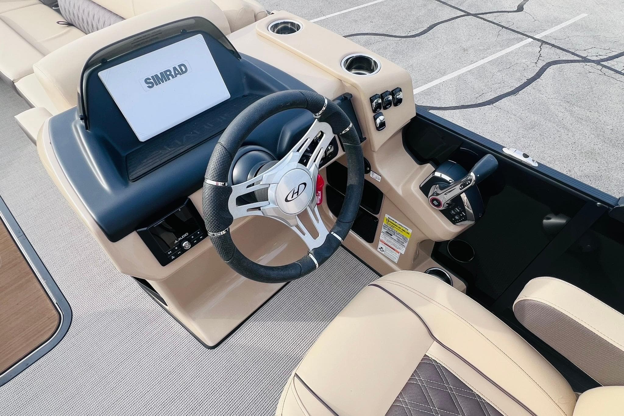 2024 Harris Sunliner 250 boat dashboard with steering wheel and Simrad display.