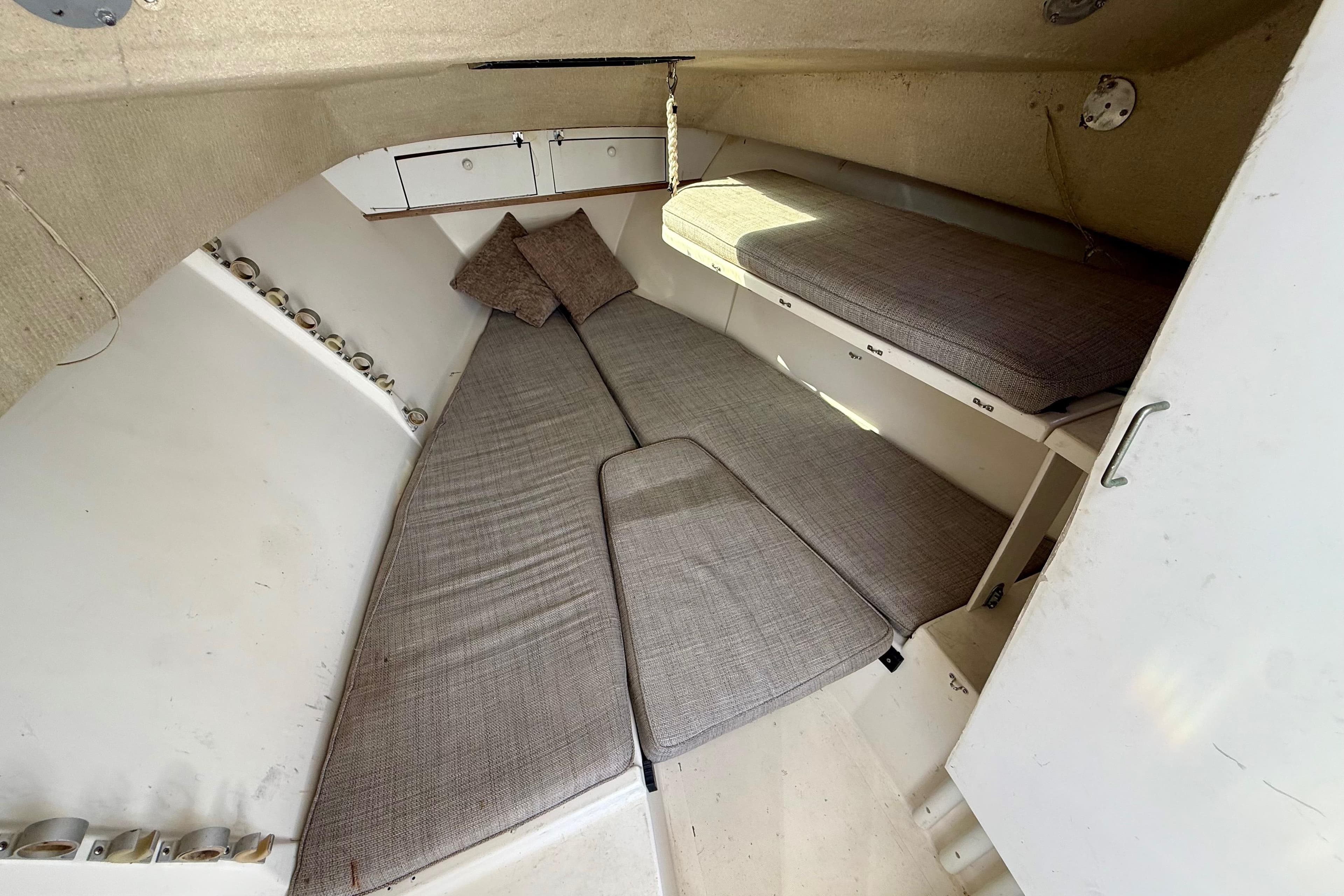 Interior cabin of a 1988 Negus 26 boat with cushioned seating and storage.