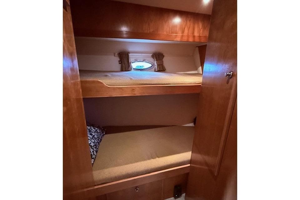 Bunk beds in 2007 Navigator 58 yacht cabin with wooden interior and porthole window.