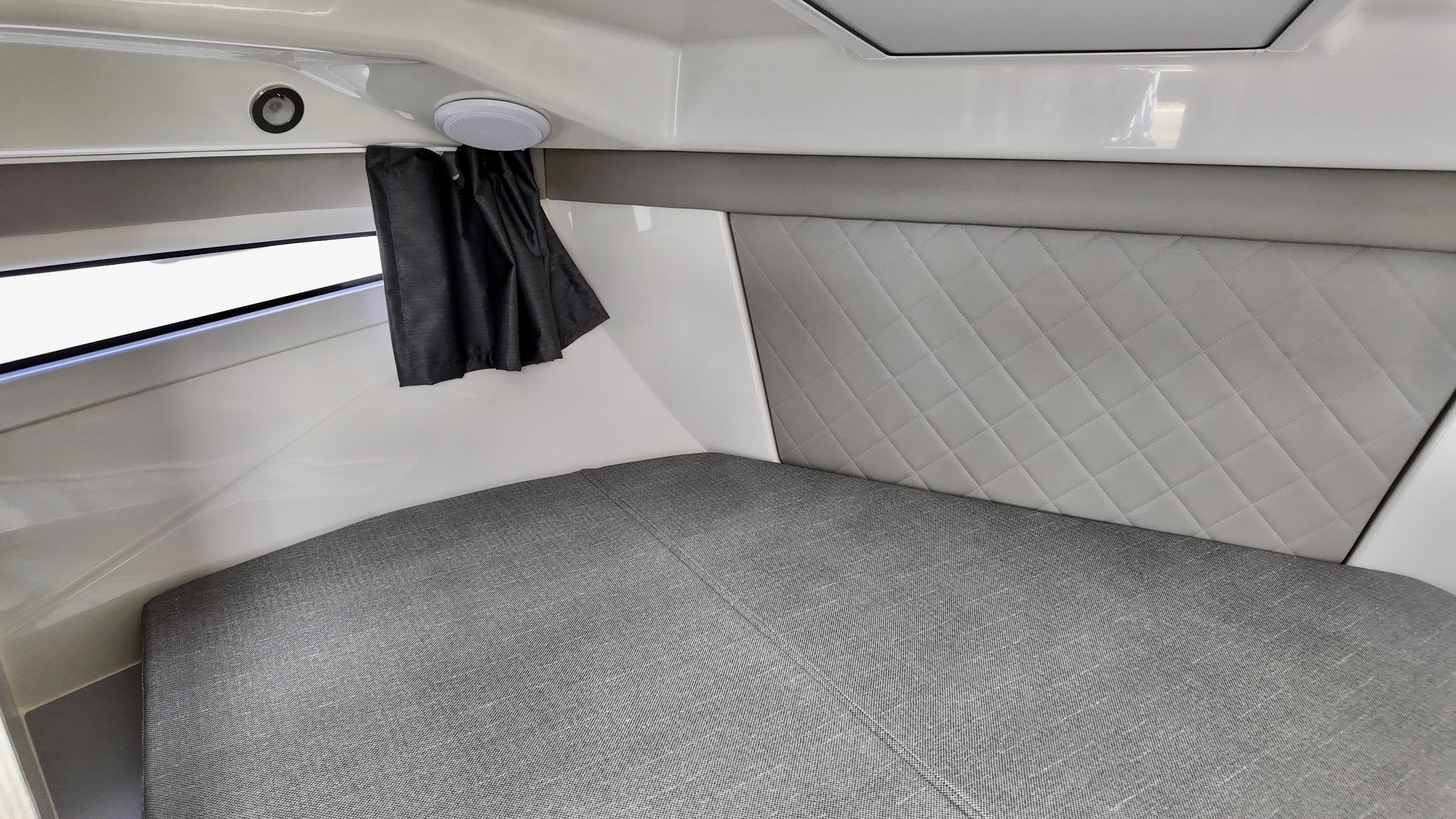 2025 Bayliner TROPHY 25 EXPLORER cabin interior with modern upholstery and window curtain.