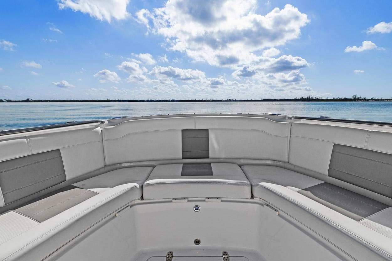 2021 Pursuit S 328 Sport boat interior with cushioned seating, ocean view, and blue sky.