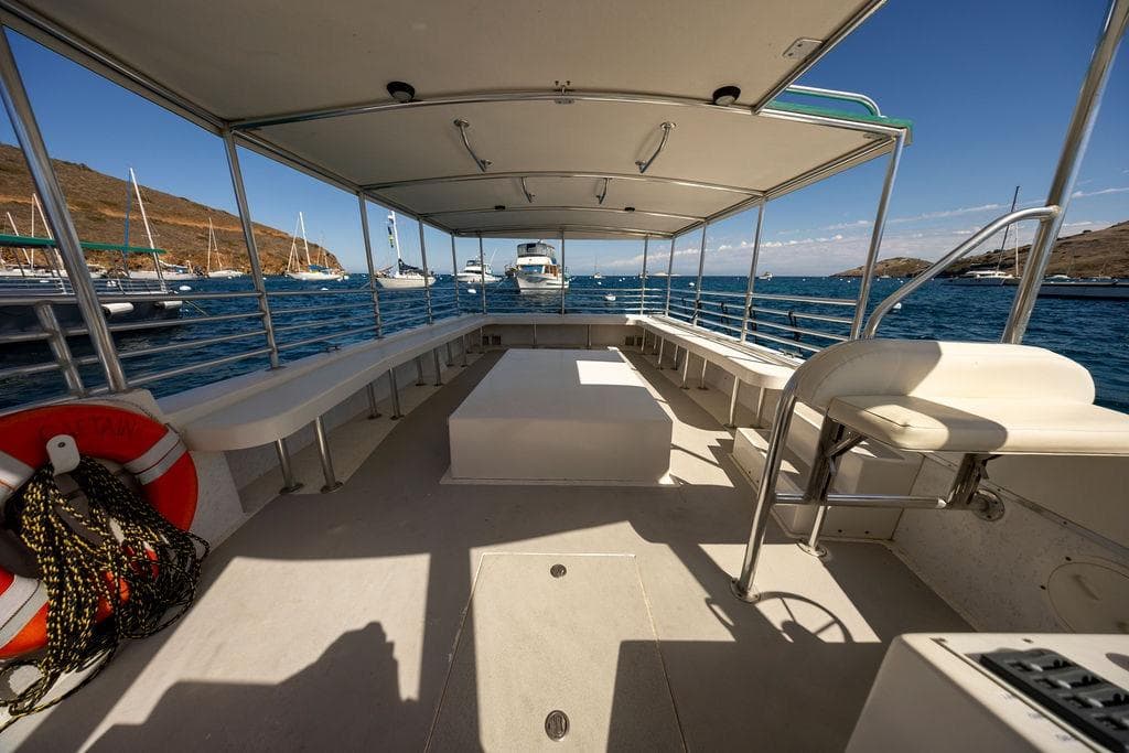 Open deck of a 2018 Seahawk Island Hopper boat, docked in a scenic marina.
