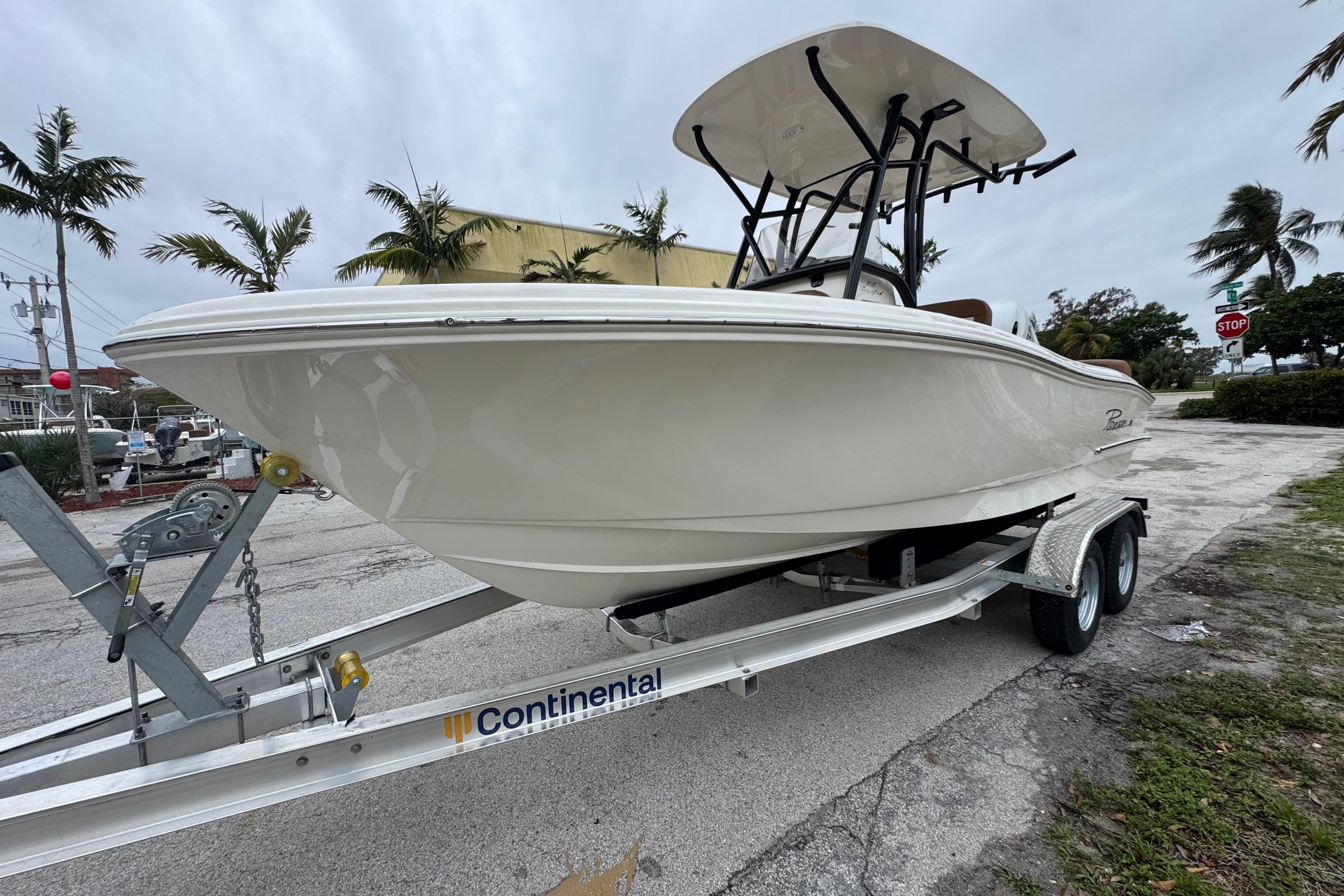 2026 Pioneer 202 Sportfish boat on trailer, parked outdoors with palm trees.