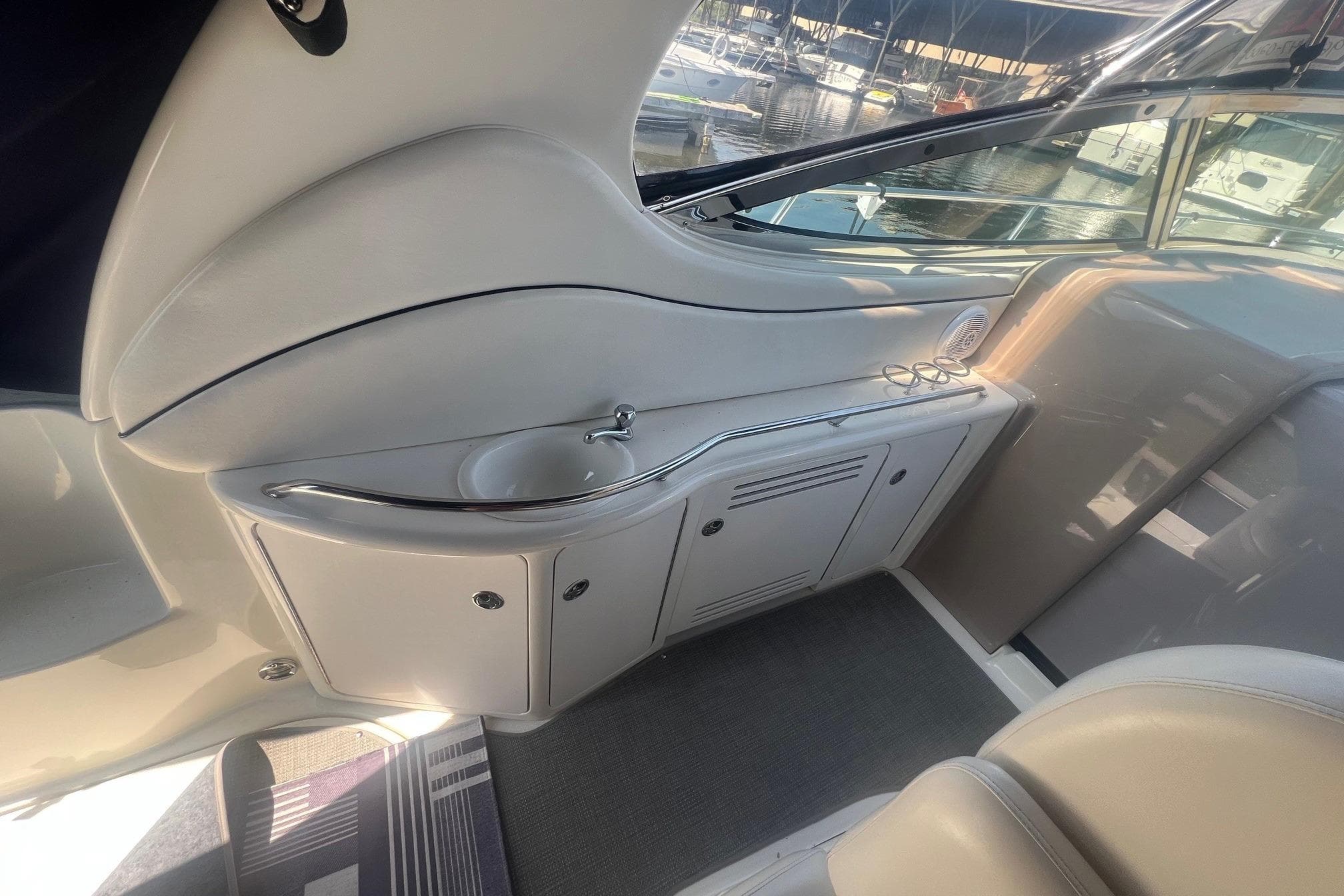 2005 Sea Ray 360 Sundancer interior with sink and storage, docked at marina.