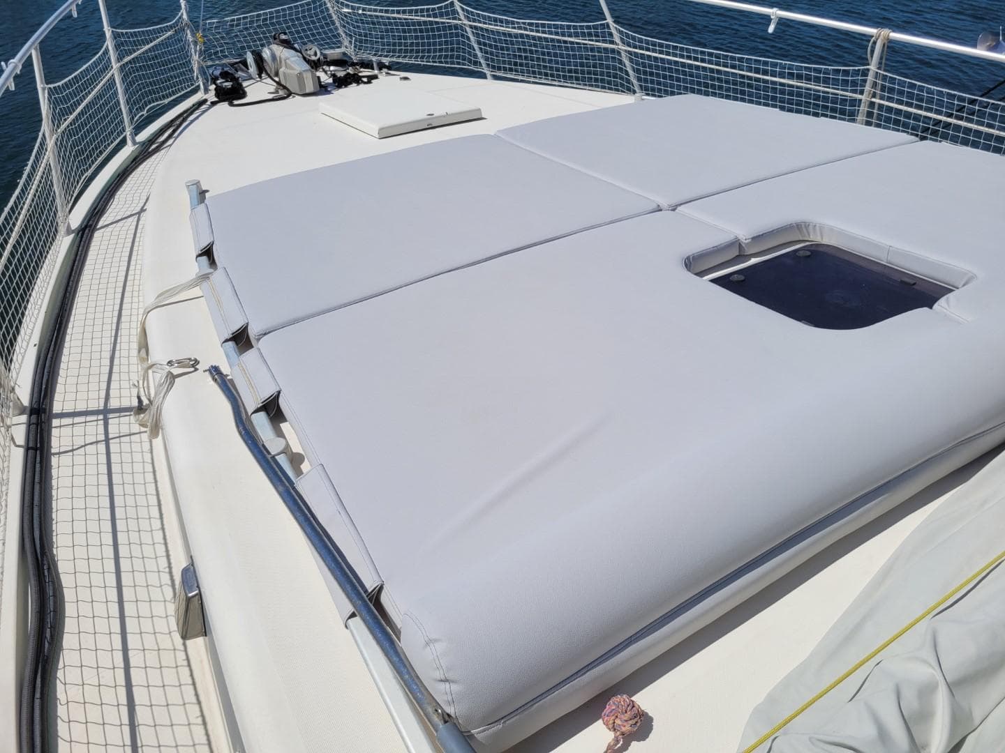 Sunbathing deck on 1992 Guy Couach 1602 yacht with cushioned seating and ocean view.