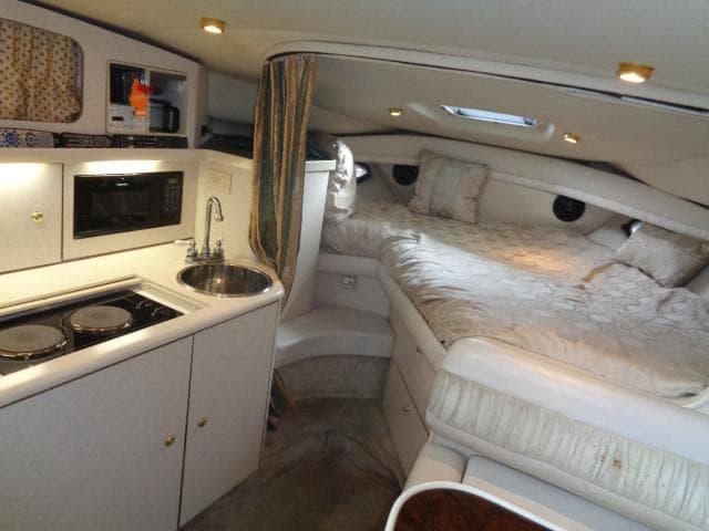 1997 Regal 292 Commodore interior with kitchenette and cozy sleeping area.
