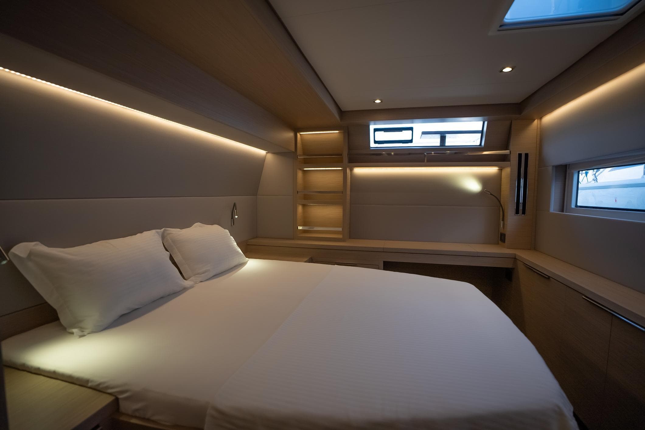 Luxurious interior of 2024 Lagoon 55 yacht with modern bedroom design.