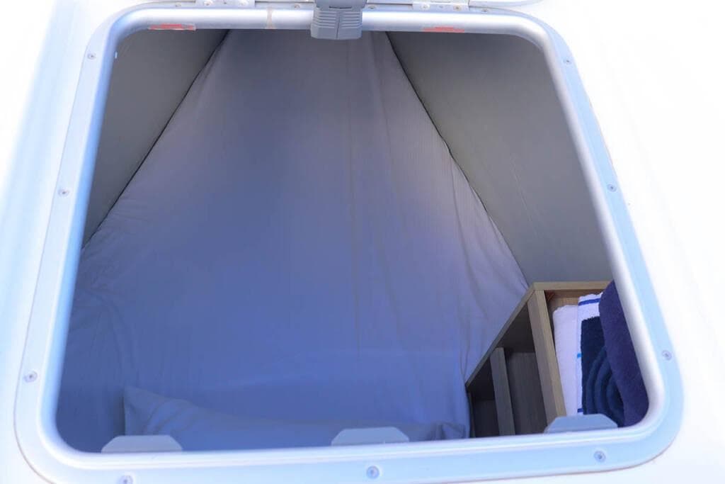 2023 Lagoon 46 yacht cabin interior with bedding and storage space.