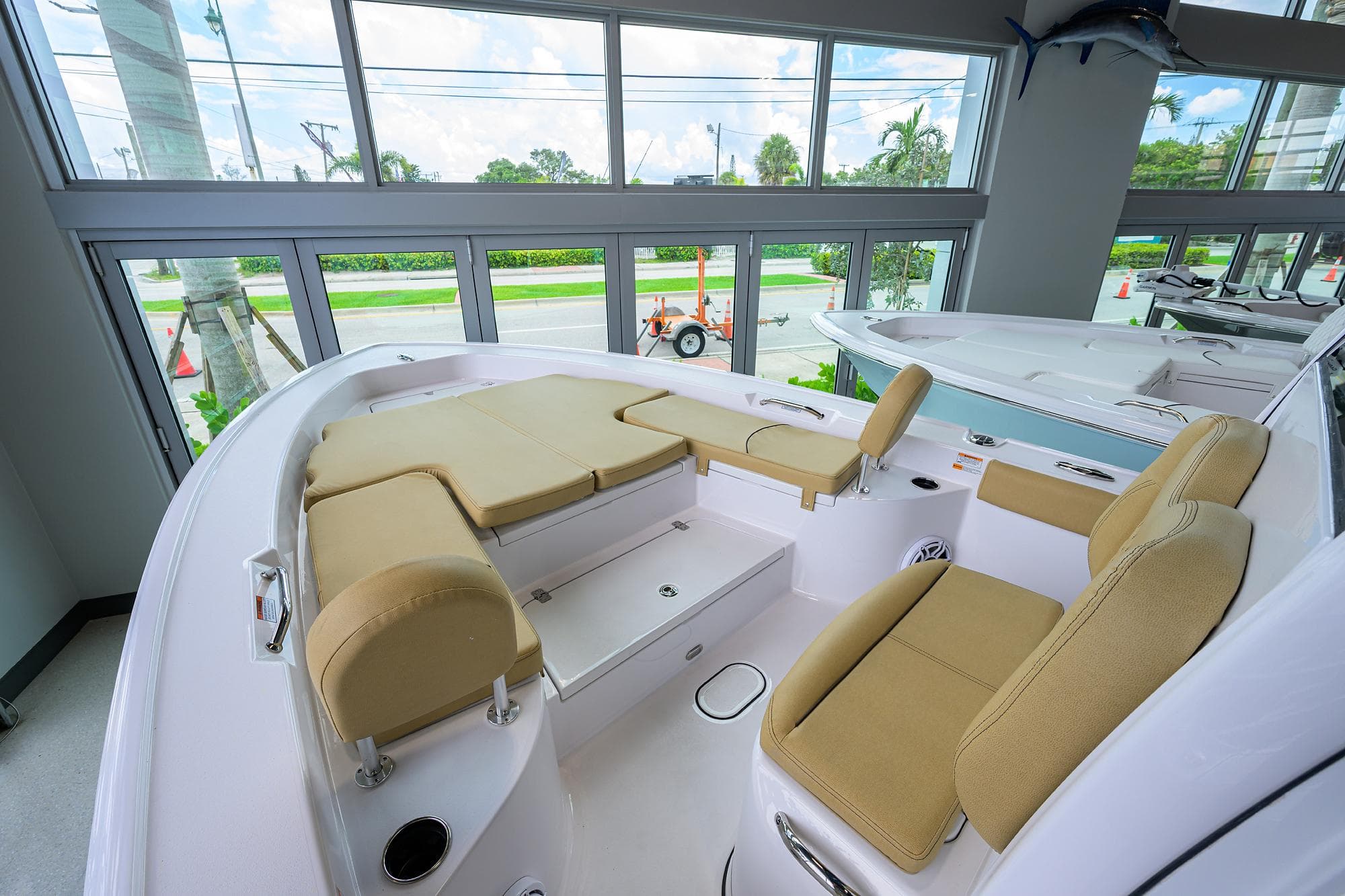 2025 Sportsman Masters 267 Bay Boat interior with beige seating, showcased in a bright showroom.