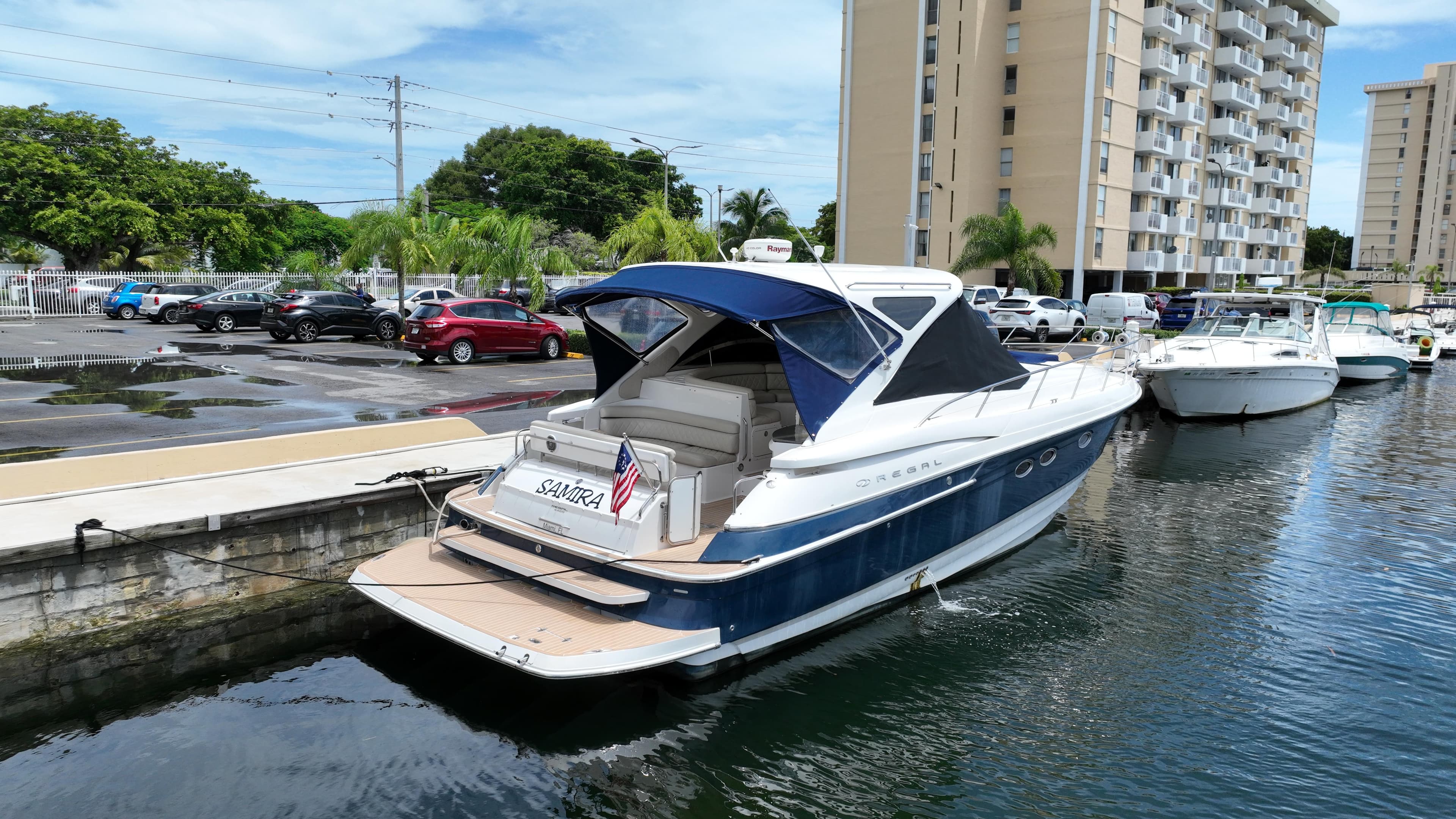 2007 Regal 4460 Commodore yacht docked in a marina with buildings in the background.