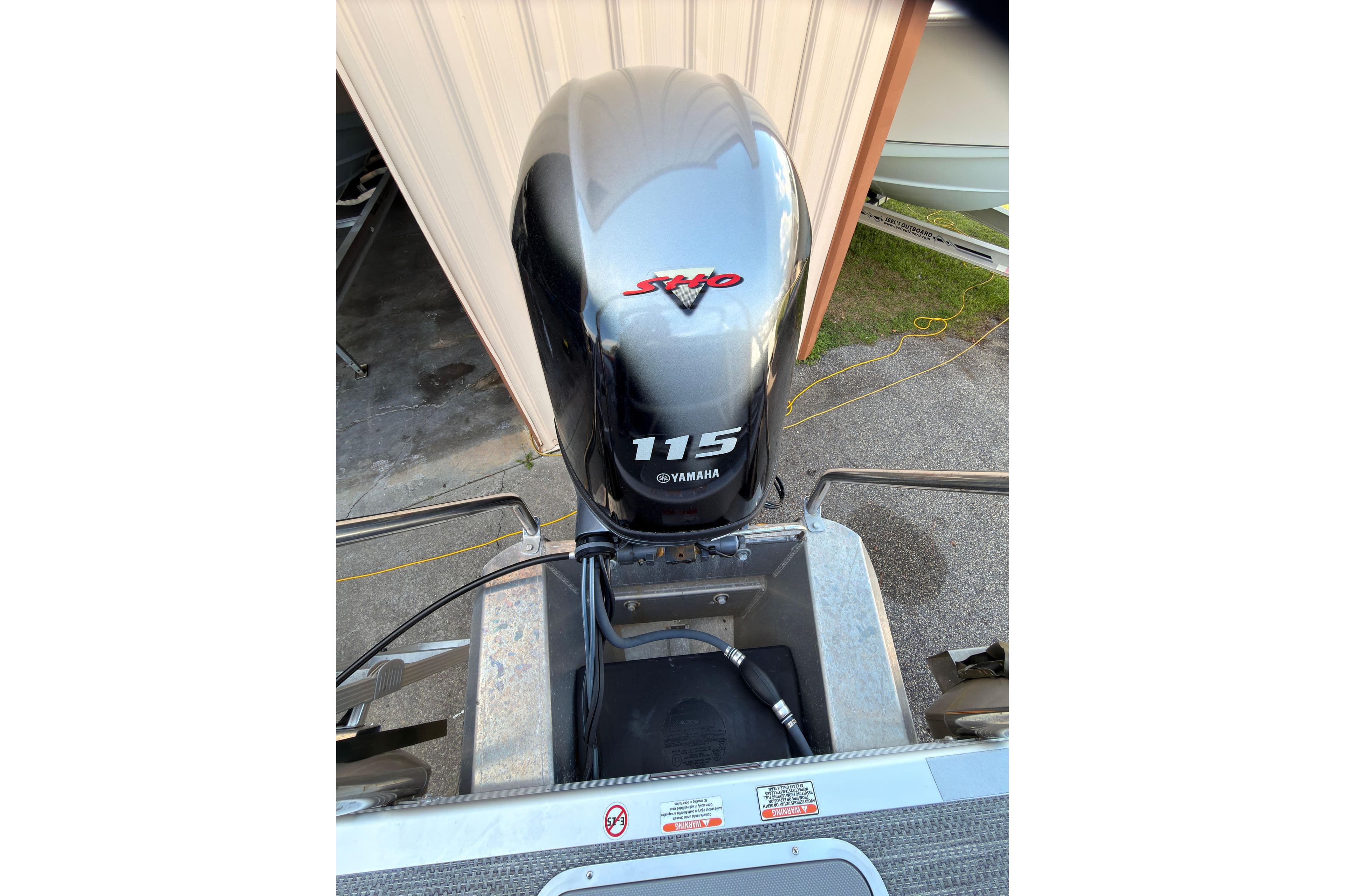 2024 Bennington SVL boat with Yamaha 115 outboard motor in a garage setting.