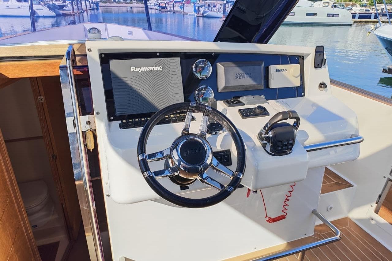 Helm of 2015 Fjord 40 Open yacht with Raymarine and Simrad navigation systems.