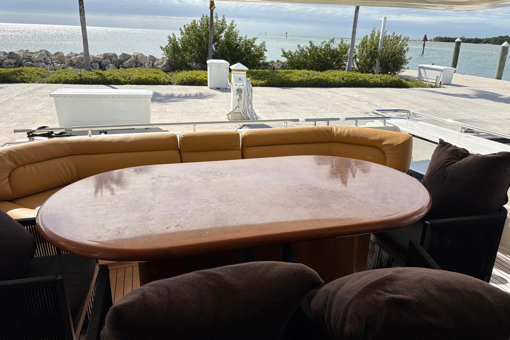 Outdoor seating area on a 1999 Ferretti Yachts 80 RPH, overlooking a scenic waterfront.
