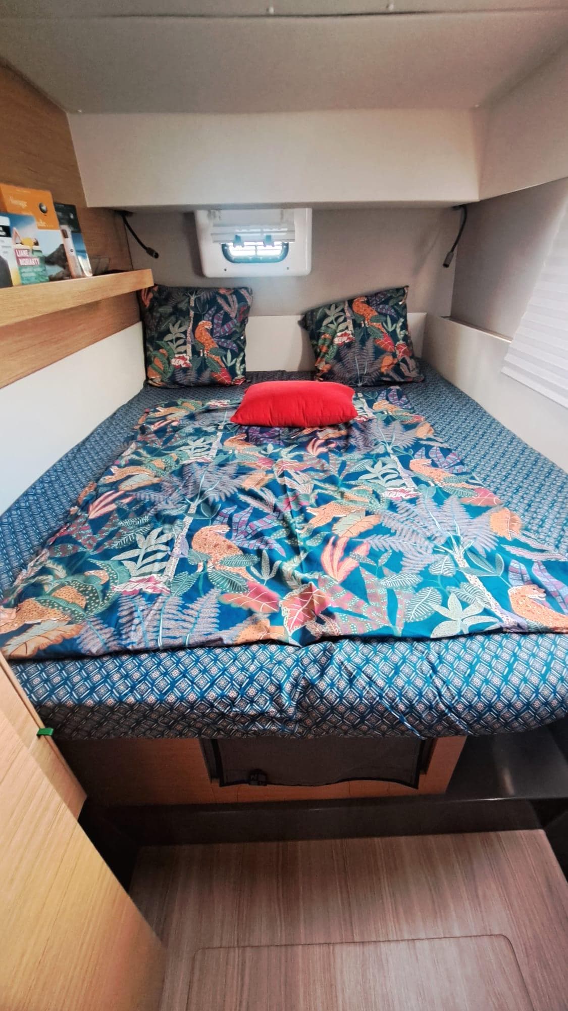 Cozy cabin interior of 2019 Nautitech 40 Open with vibrant bedding and wooden accents.