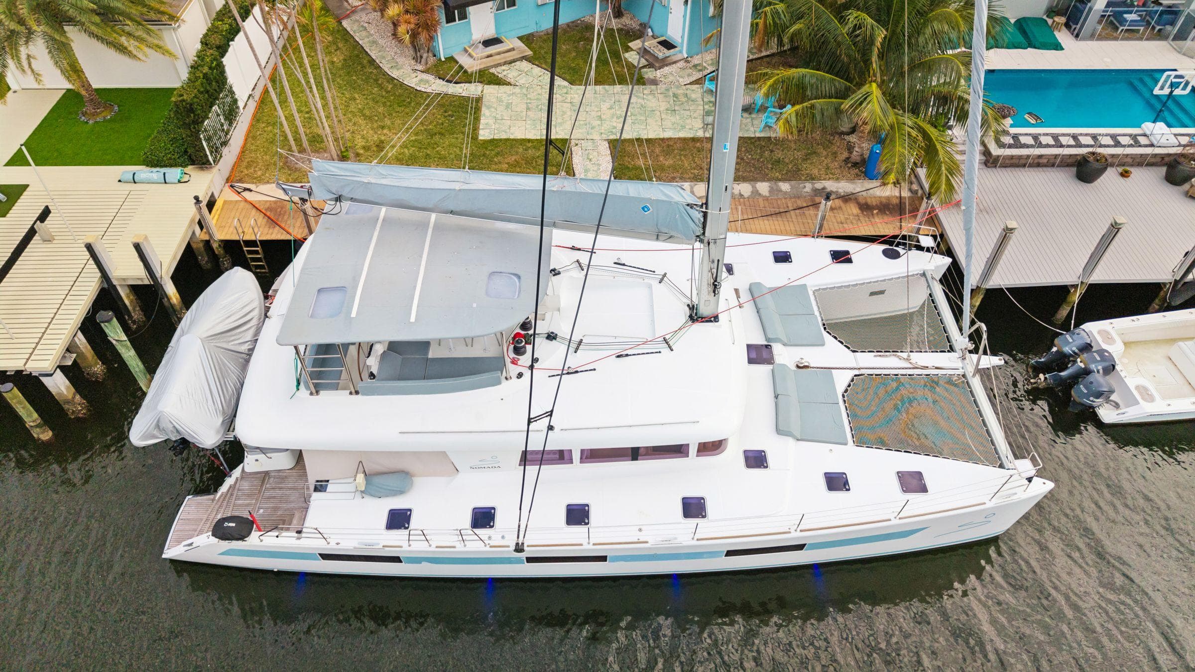 2014 Lagoon 620 catamaran docked near waterfront property, aerial view.