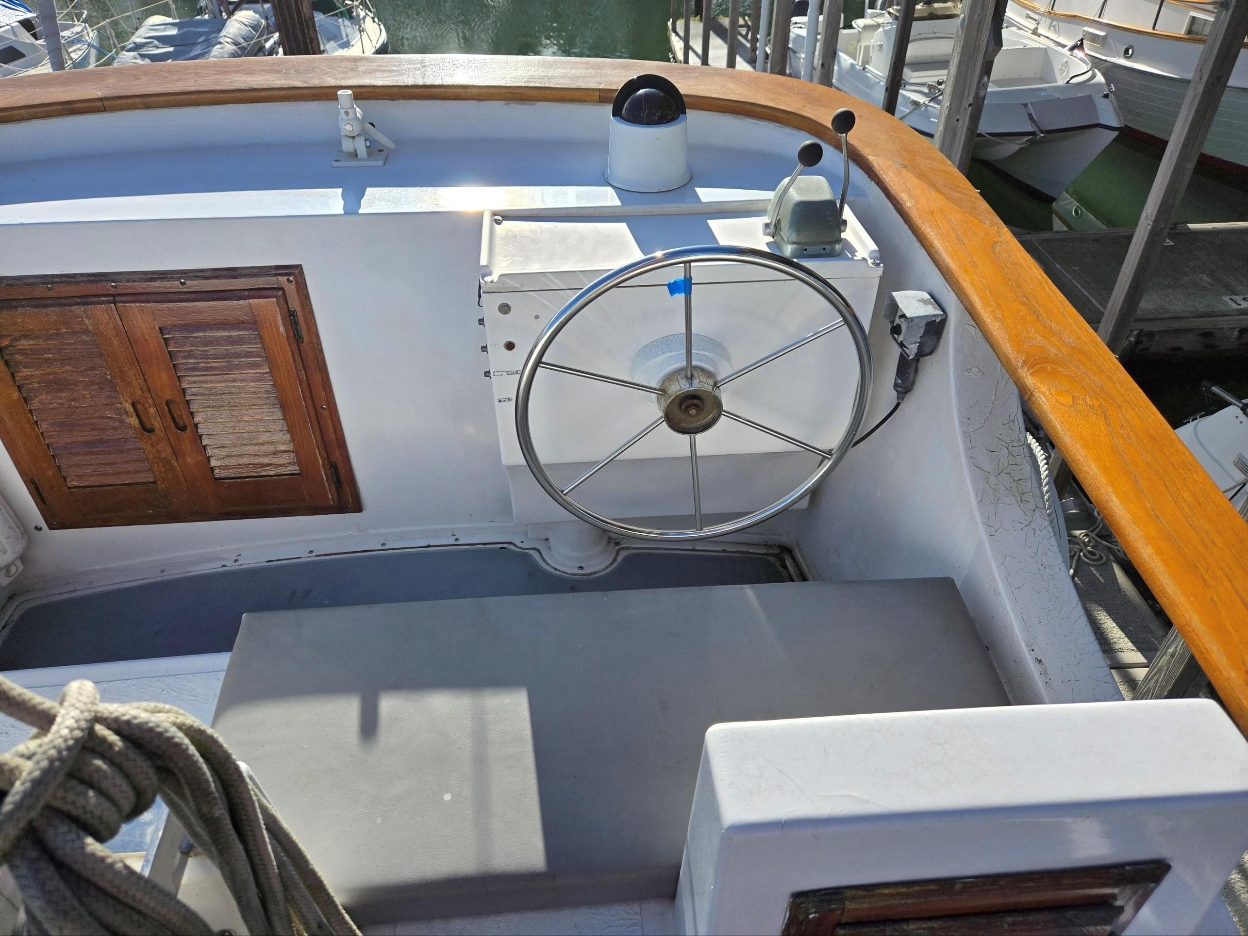 1974 Willard Nomad boat helm with wooden accents and steering wheel.