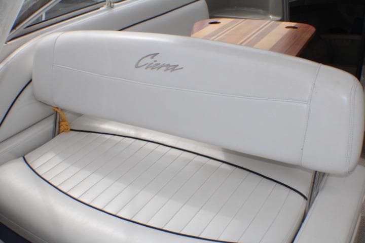 1998 Bayliner 2655 Ciera Sunbridge interior with white seating and wooden table.