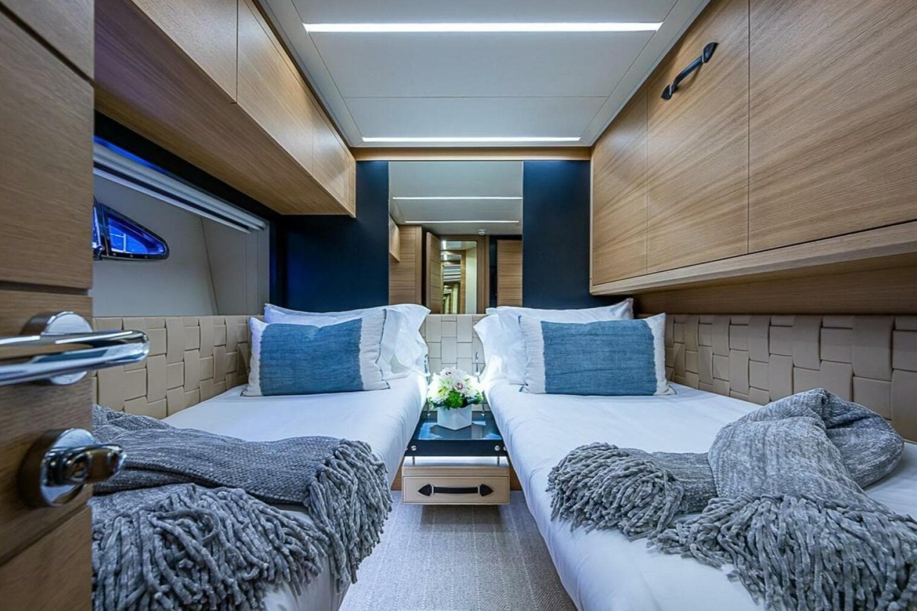 Luxurious twin cabin interior of 2014 Pershing 92 yacht with modern decor and cozy bedding.