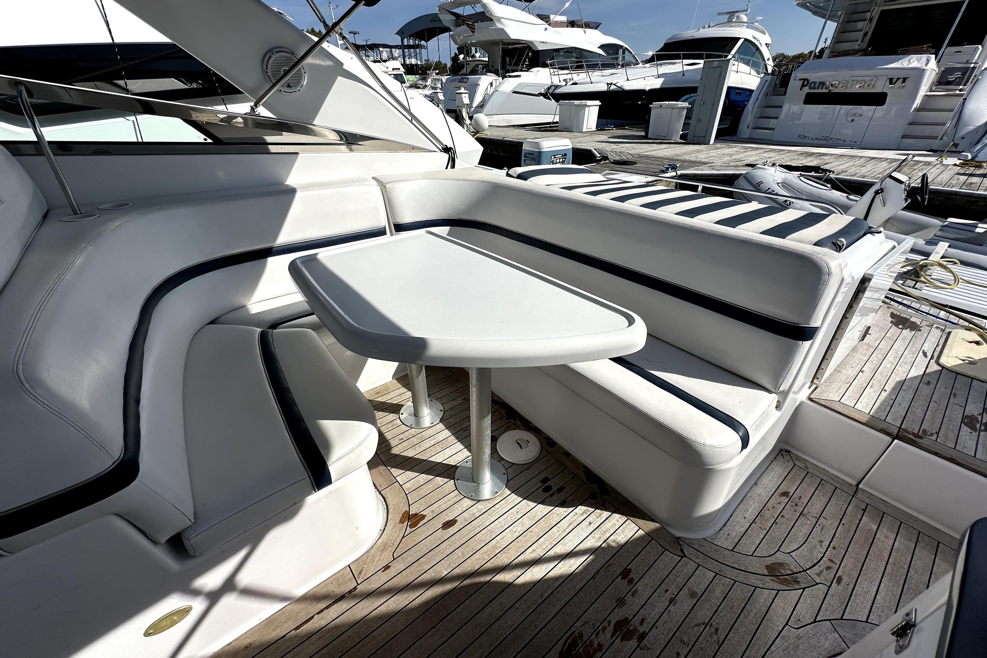 2003 Donzi 39 ZSC yacht interior with white seating and table, docked at marina.