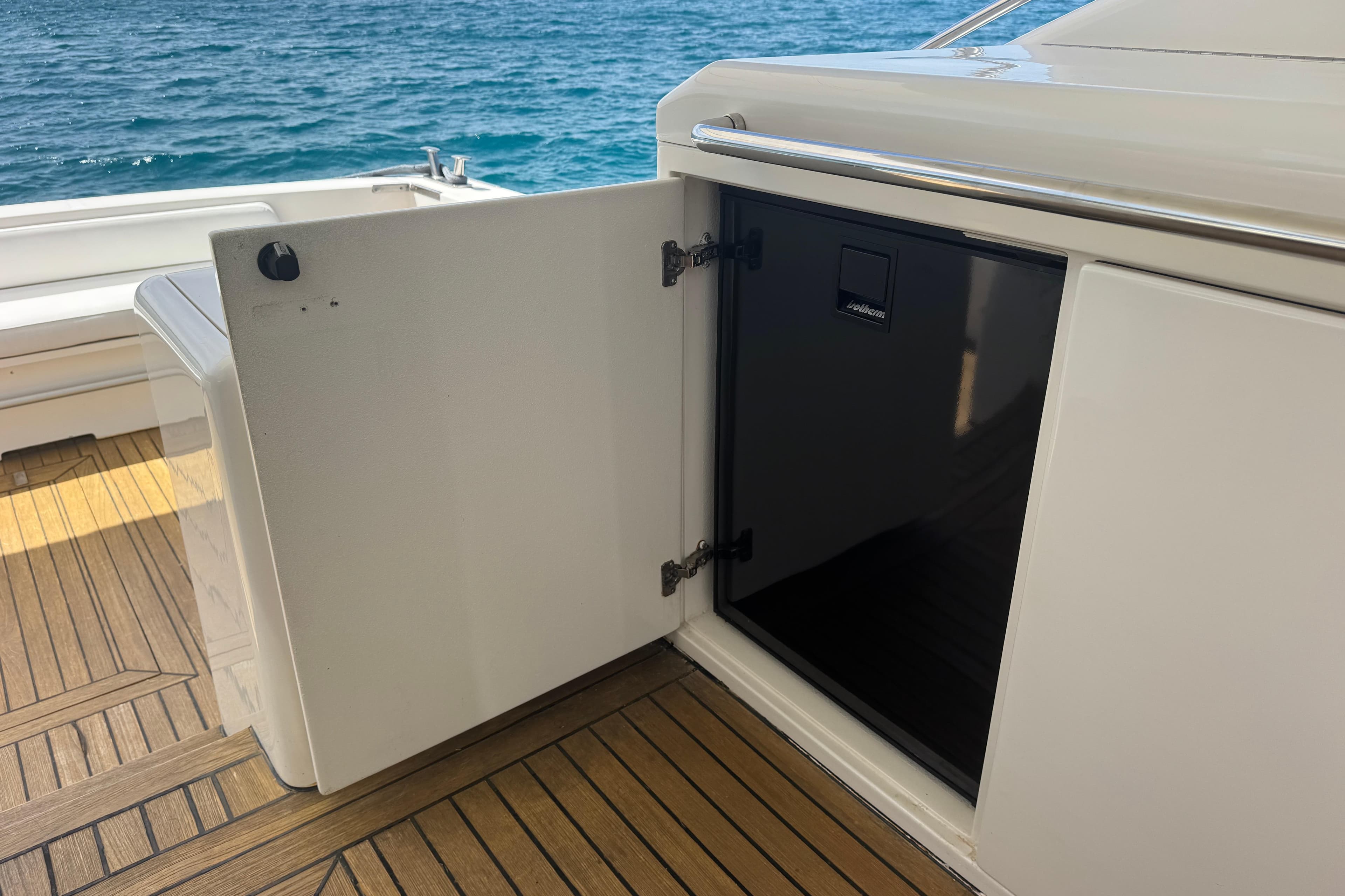 Open storage compartment on 2013 Uniesse 49 yacht with wooden deck and ocean view.