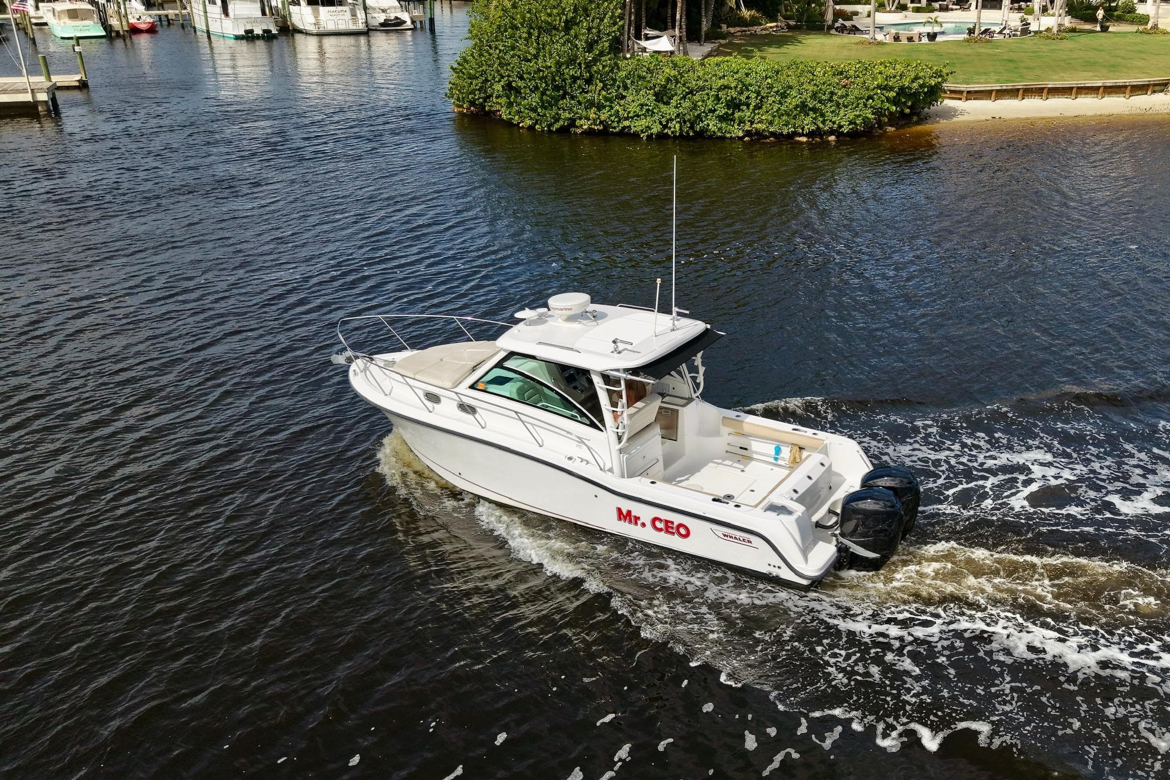 2015 Boston Whaler 315 Conquest boat cruising on a calm waterway.