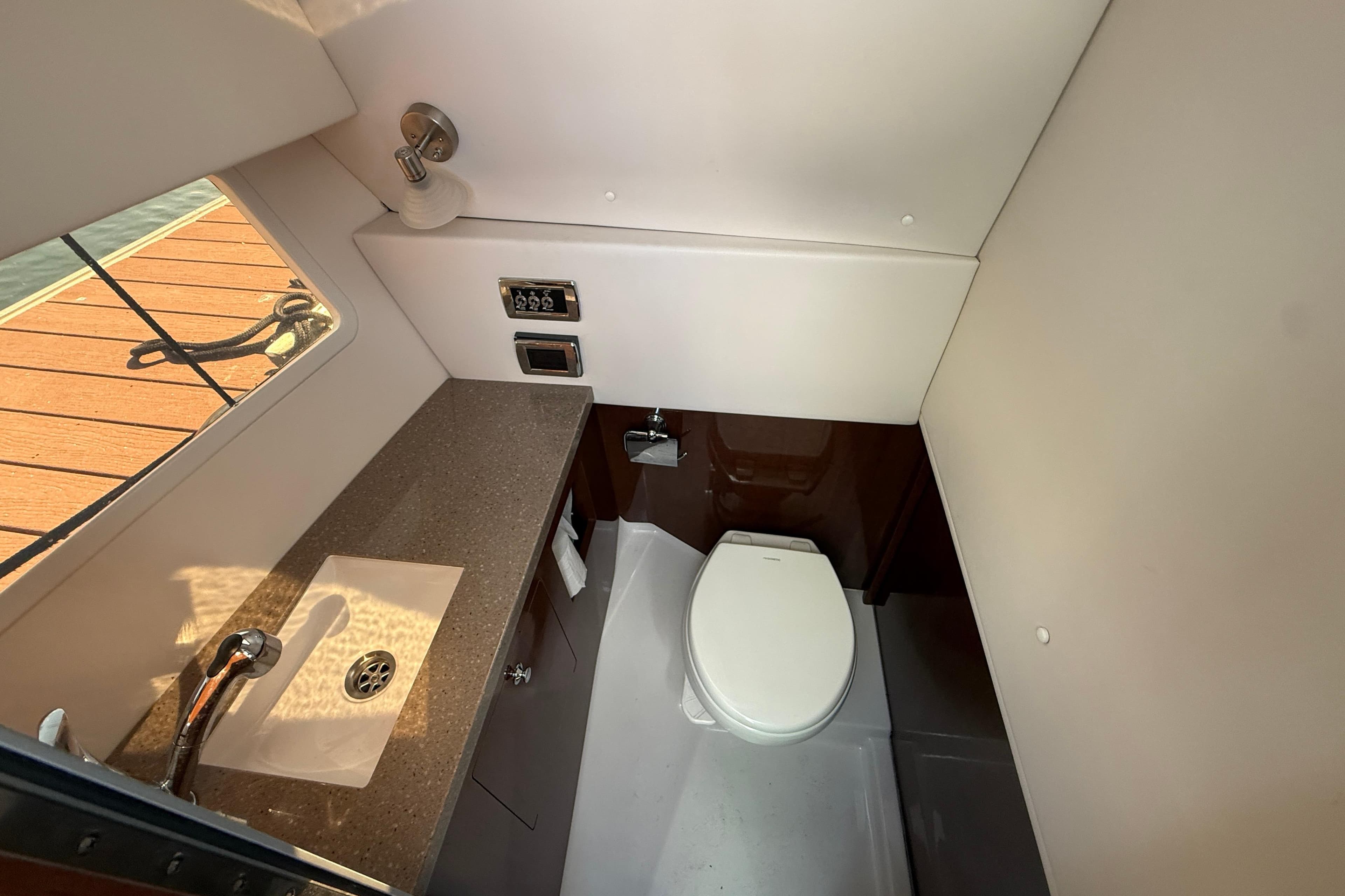 2018 Four Winns H350 boat bathroom with sink, toilet, and window view.