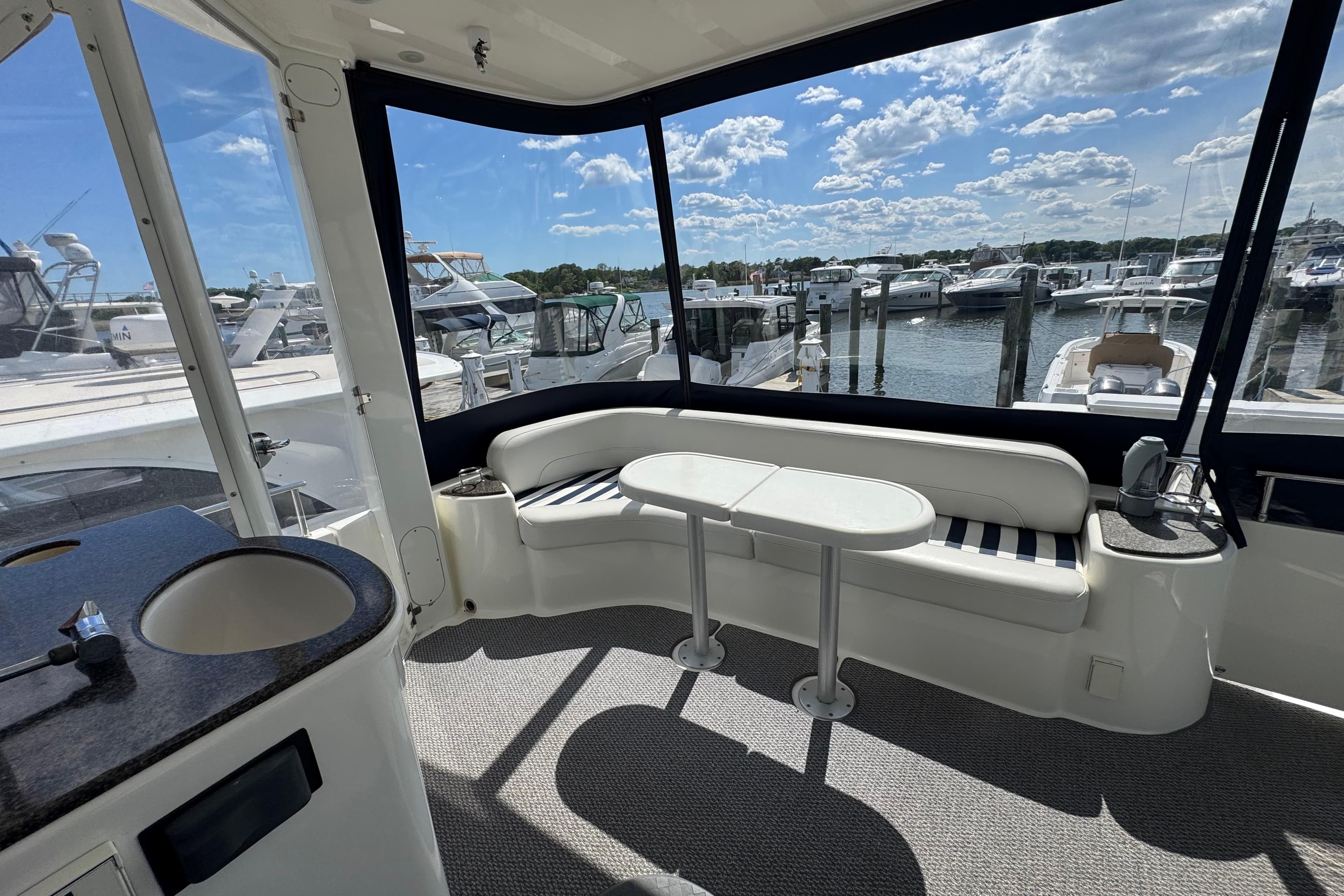 Interior view of 2006 Meridian 459 Motoryacht with seating and marina backdrop.