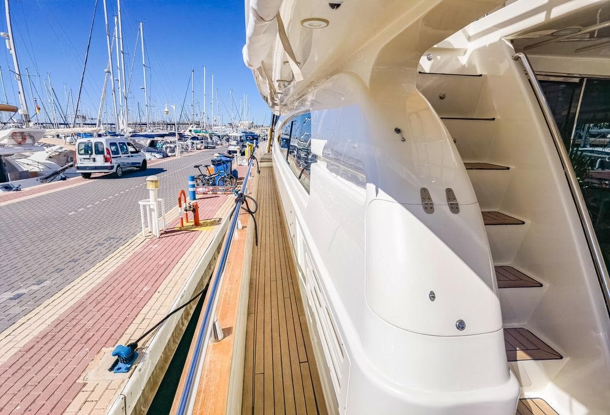 Astondoa 95 GLX yacht docked at marina, showcasing sleek design and wooden deck.