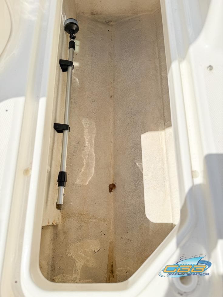 Storage compartment of 2015 Sea Ray 240 Sundeck boat, featuring a telescopic pole.