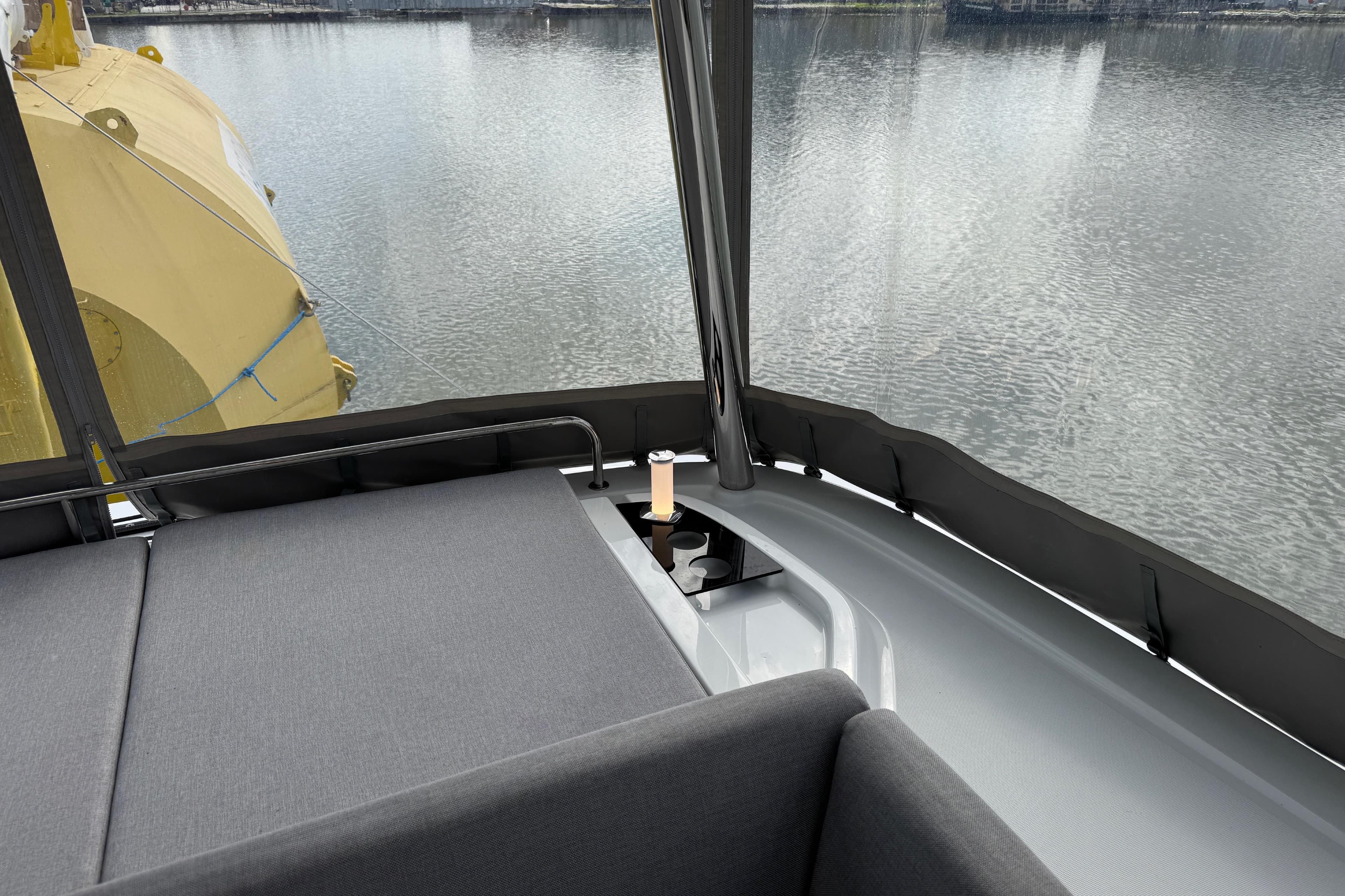 Luxurious Lagoon 55 yacht interior with comfortable seating, overlooking serene water.