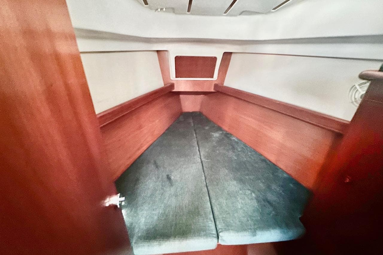 Interior cabin of 2000 Beneteau 361 sailboat with wooden finish and cushioned seating.