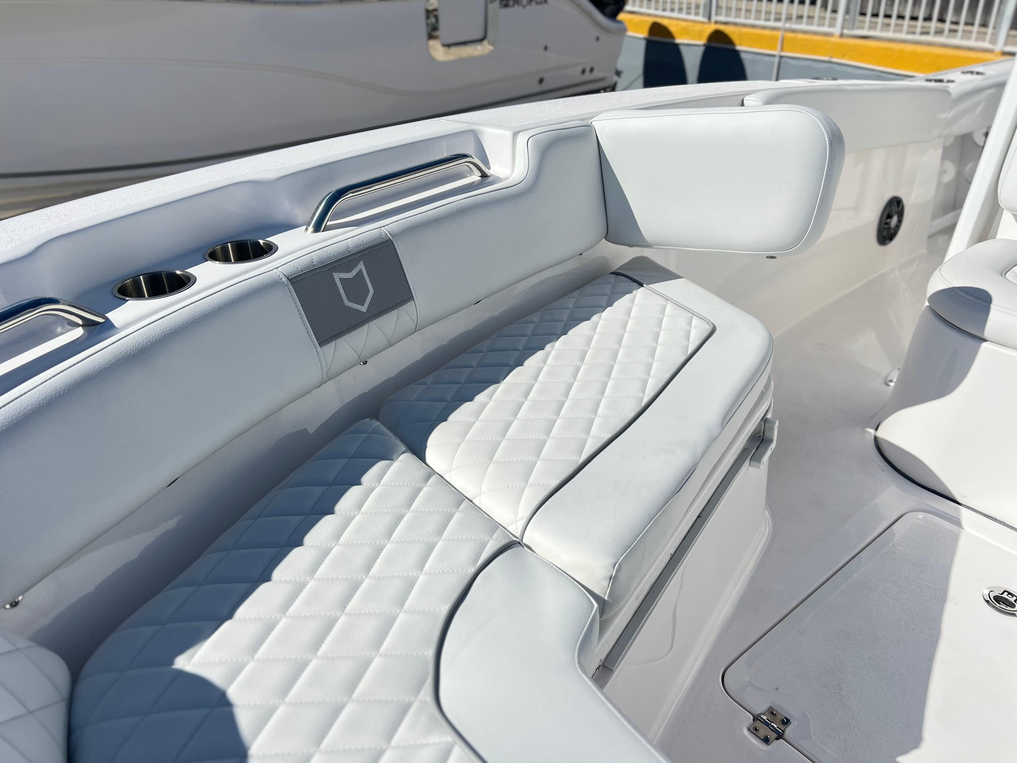 2025 Sea Fox 248 Commander boat interior with white cushioned seating and cup holders.
