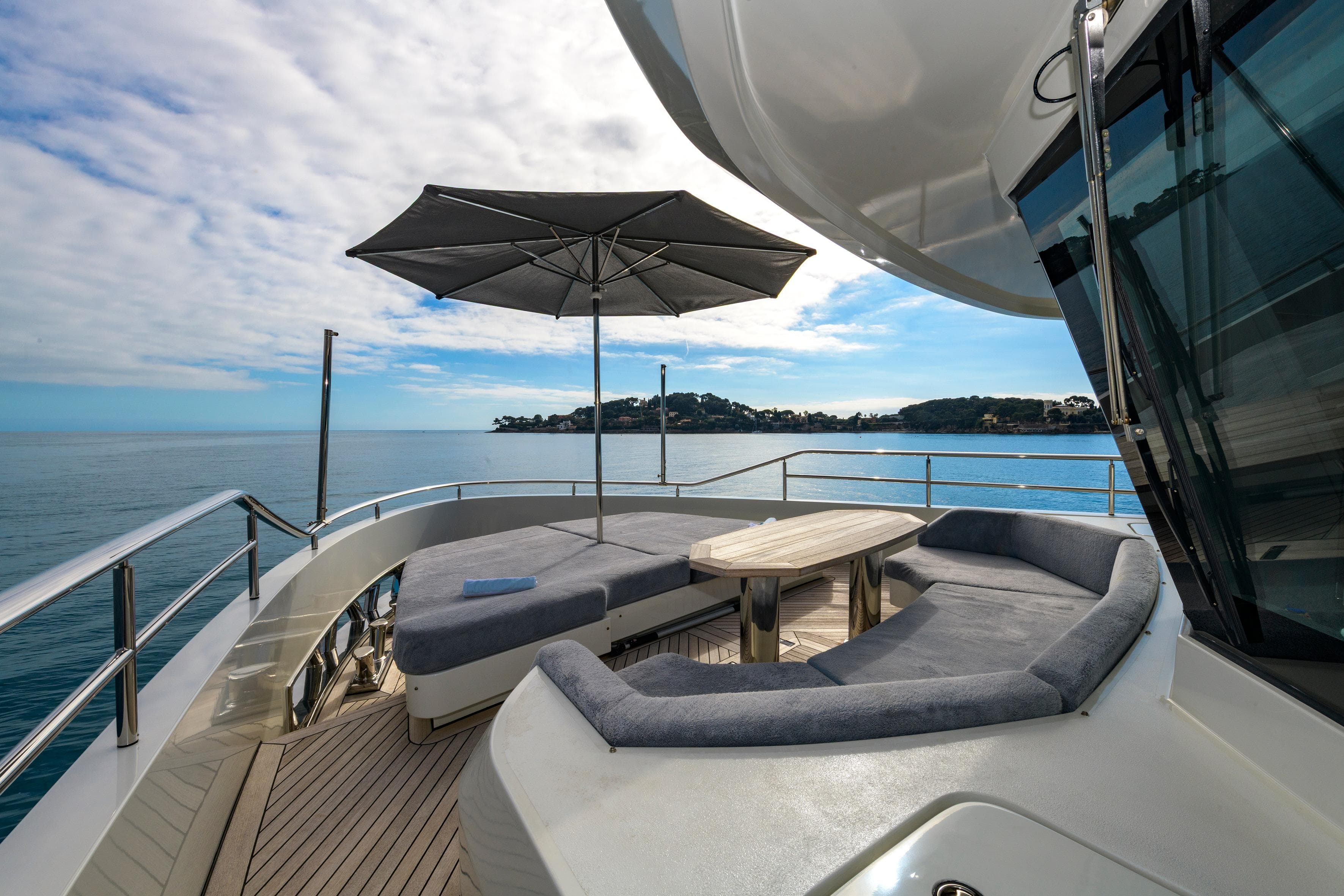 Luxurious deck of 2023 Blaundus V30 Explorer yacht with seating and umbrella.