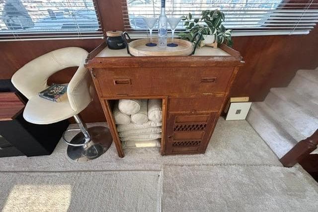 1981 Ocean Alexander 50 Pilothouse interior with wooden cabinet, chair, and decor elements.