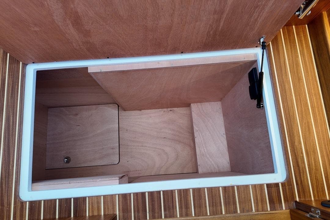 Storage compartment in 2026 Targa 41 boat with wooden interior finish.