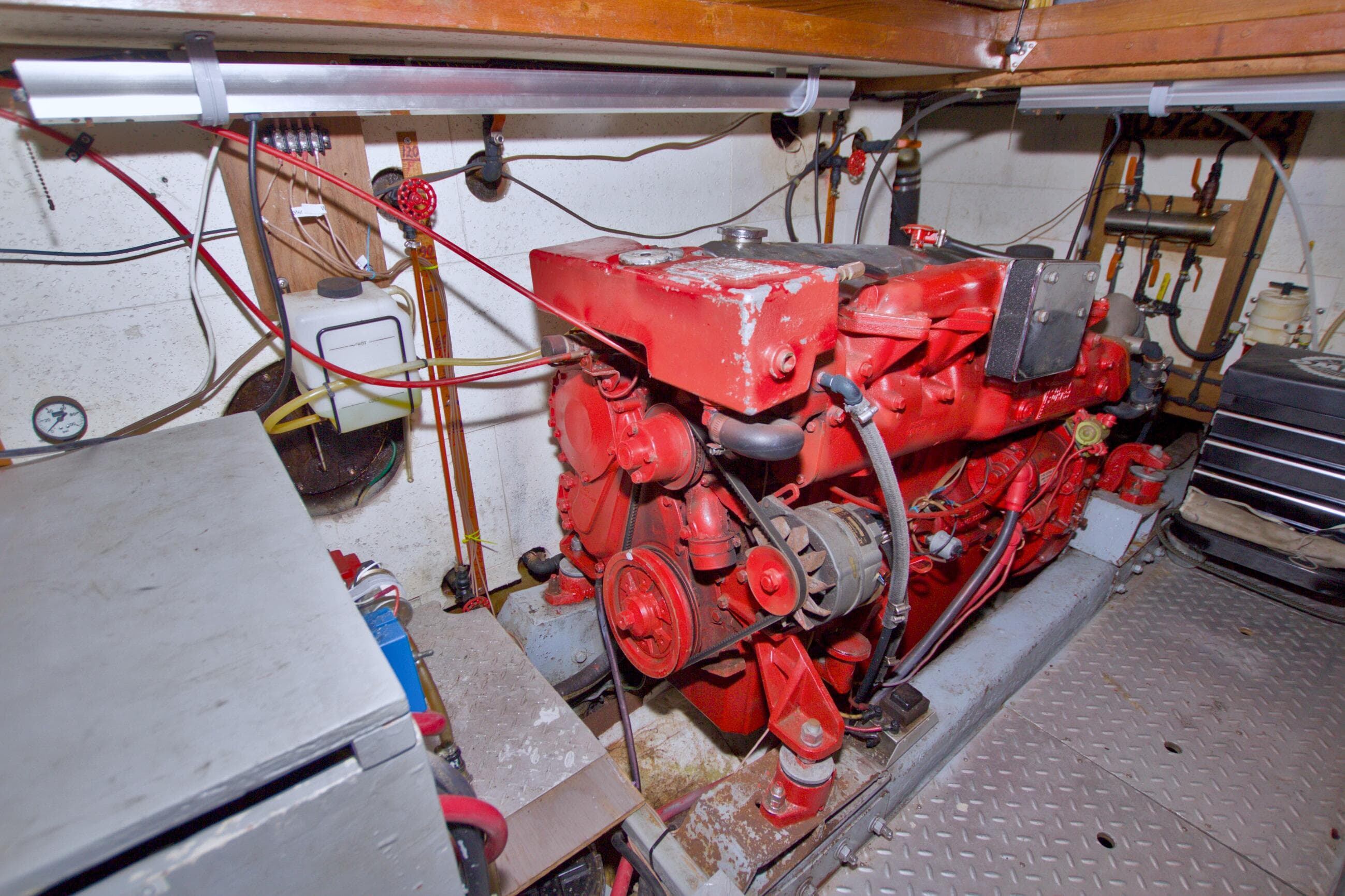 Engine room of 1984 Present Yachts 42 Sundeck with red machinery and wiring.