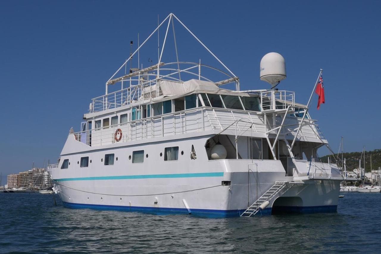 Poseidon 1988 motor catamaran on water, featuring a white hull and blue accents.