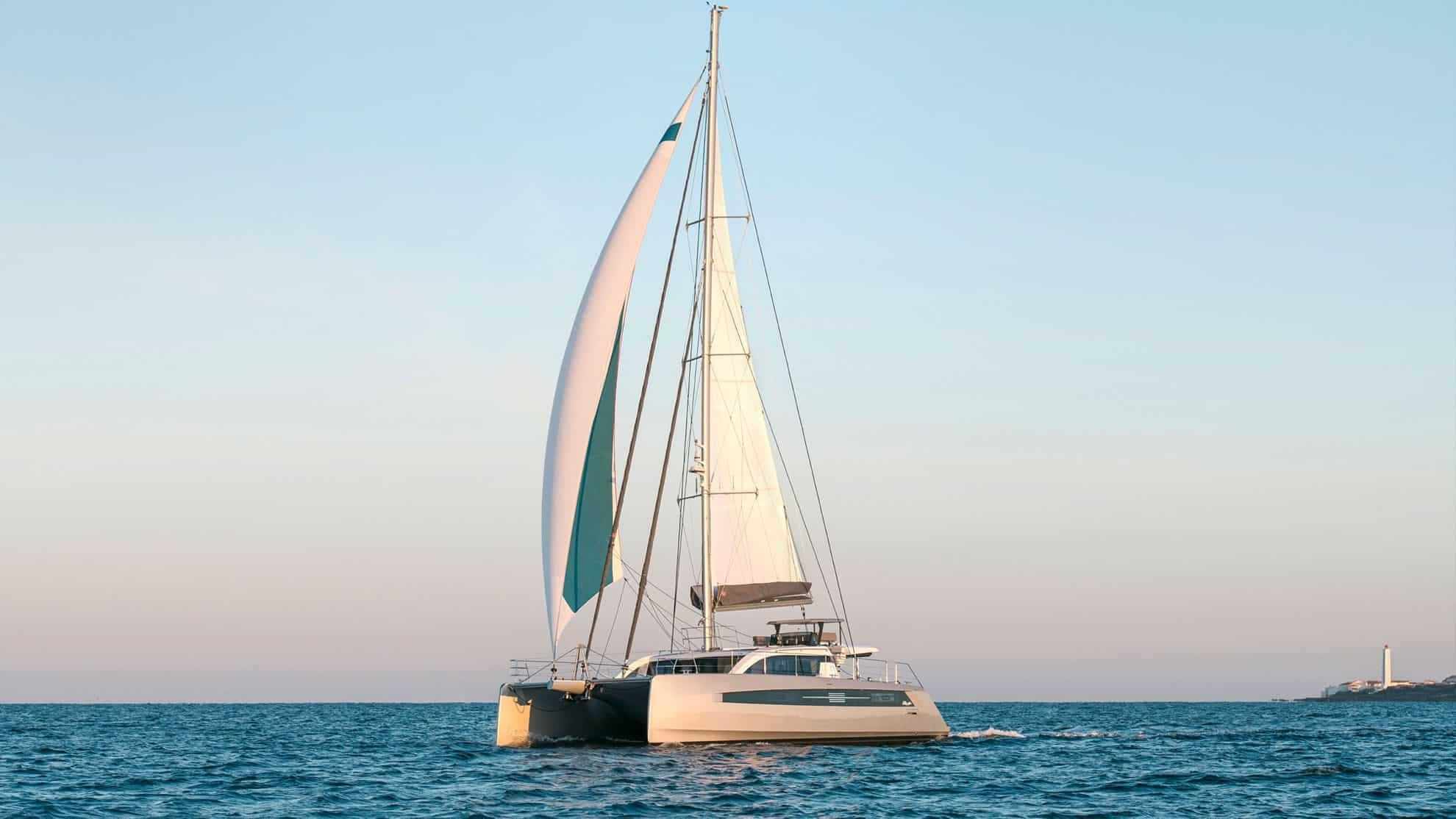 2025 Privilege Signature 580 catamaran sailing on calm ocean waters.