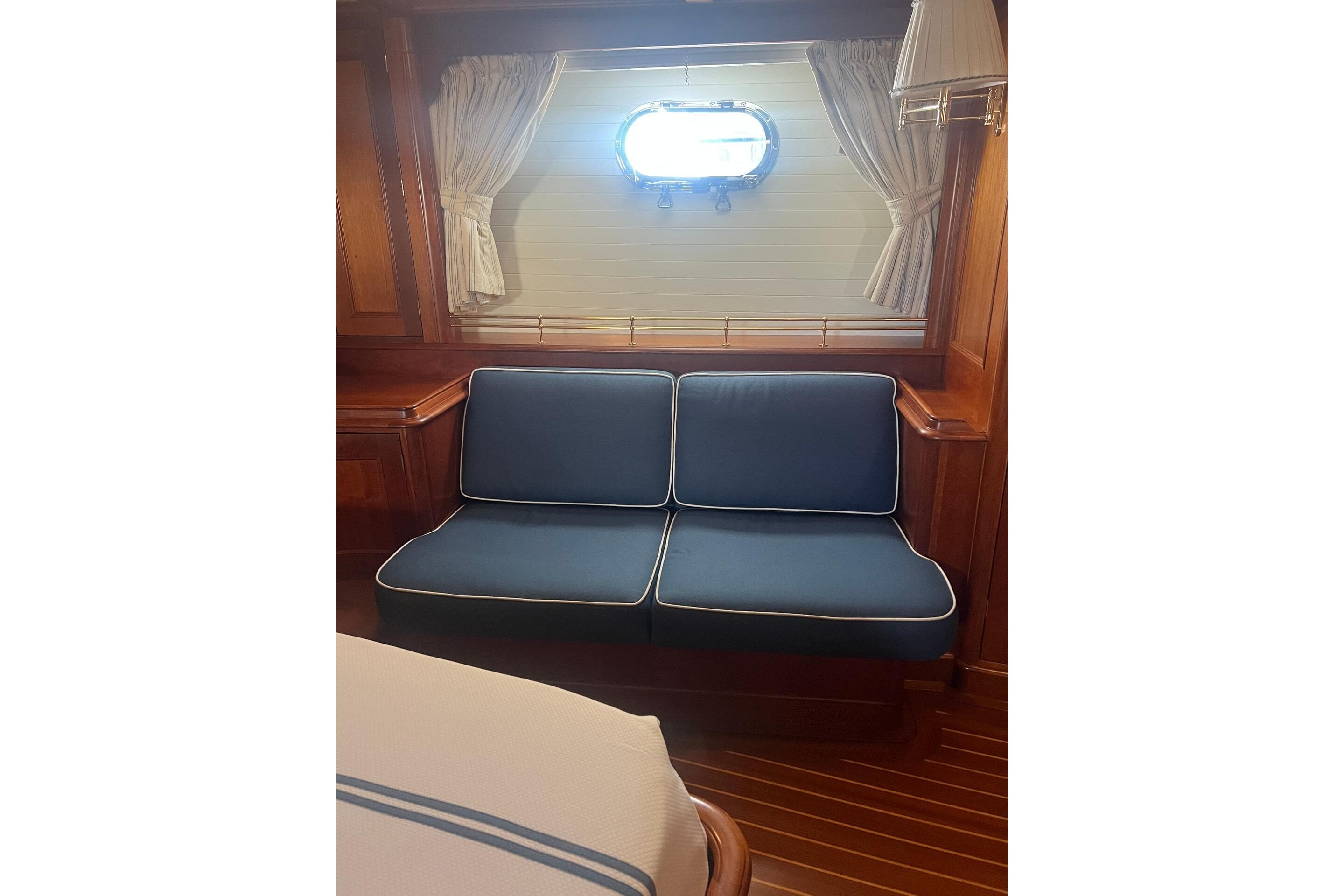 Interior of 1992 Palmer Johnson Cruising Ketch with blue cushioned seating and wooden accents.
