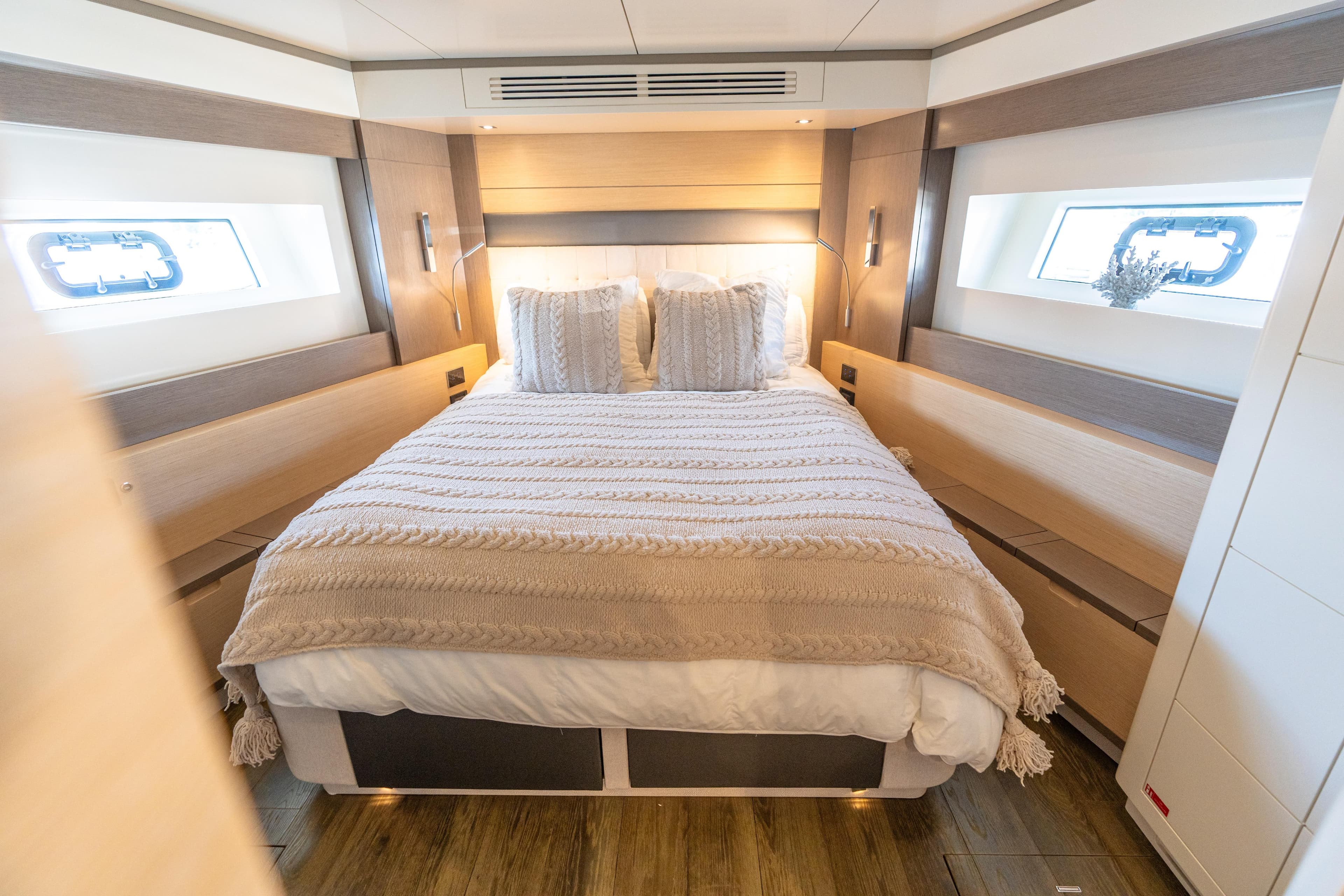 Luxurious bedroom interior of 2019 Sirena 64 yacht with cozy bedding and modern design.