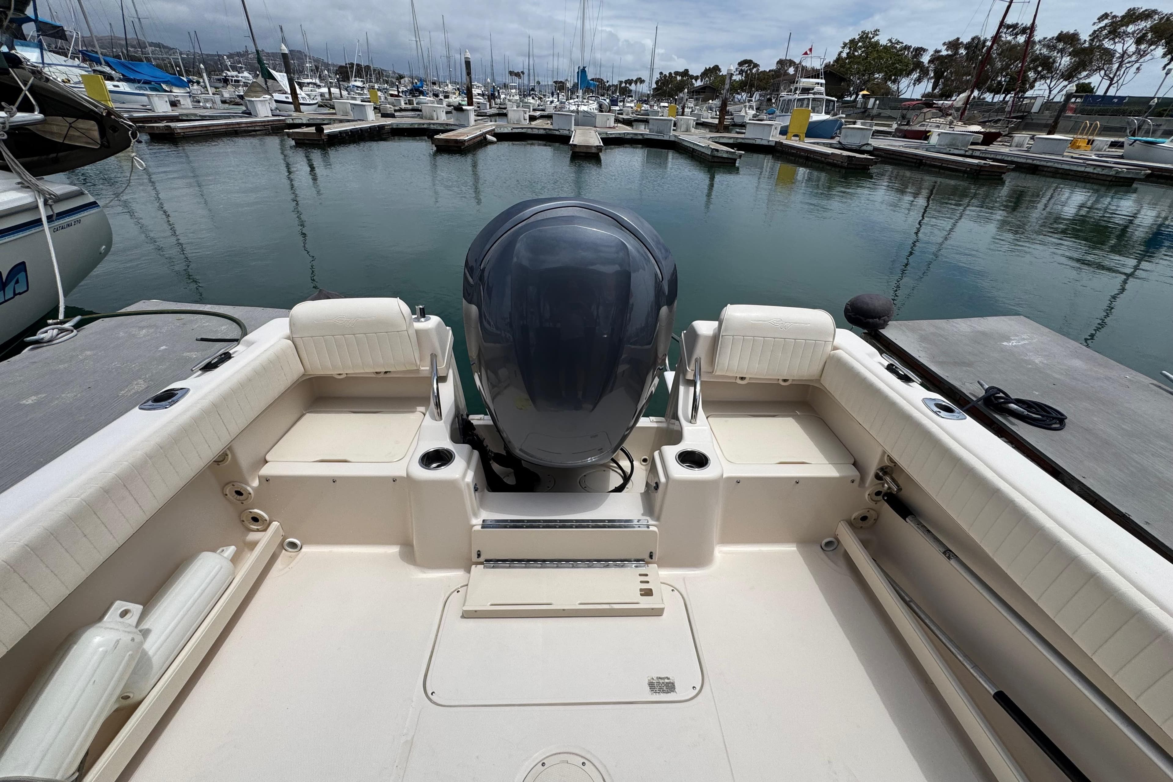 2012 Grady-White Adventure 208 boat docked at a marina, showcasing spacious seating and motor.