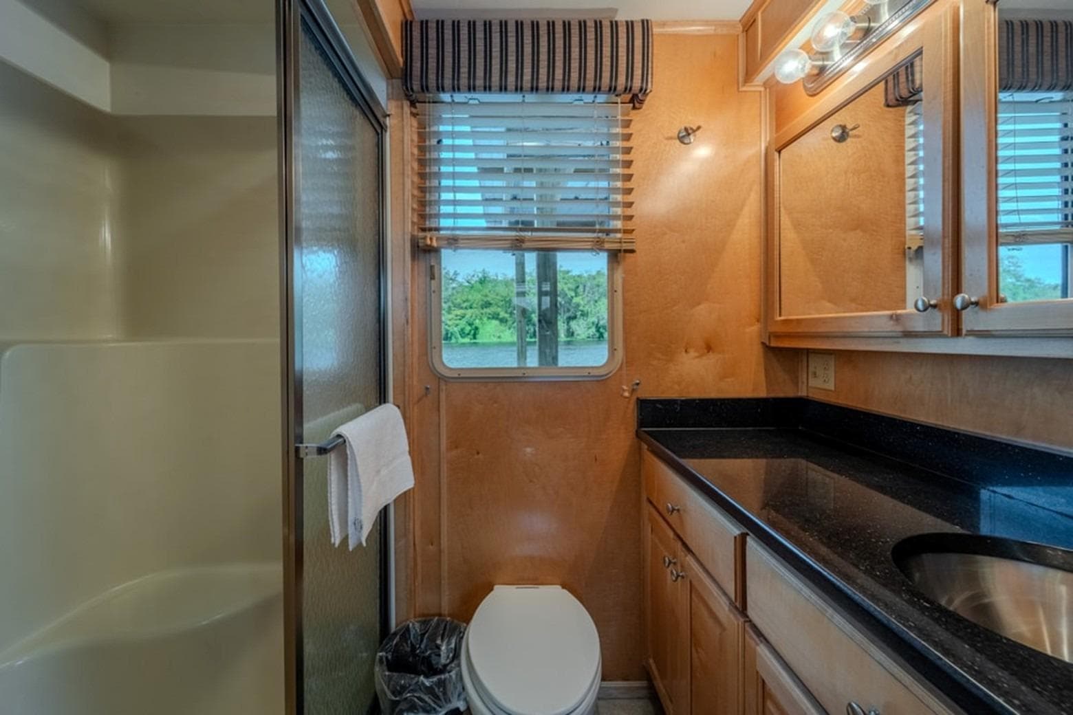 Bathroom interior of 2014 Sunstar Houseboats 55, featuring shower, sink, and window view.