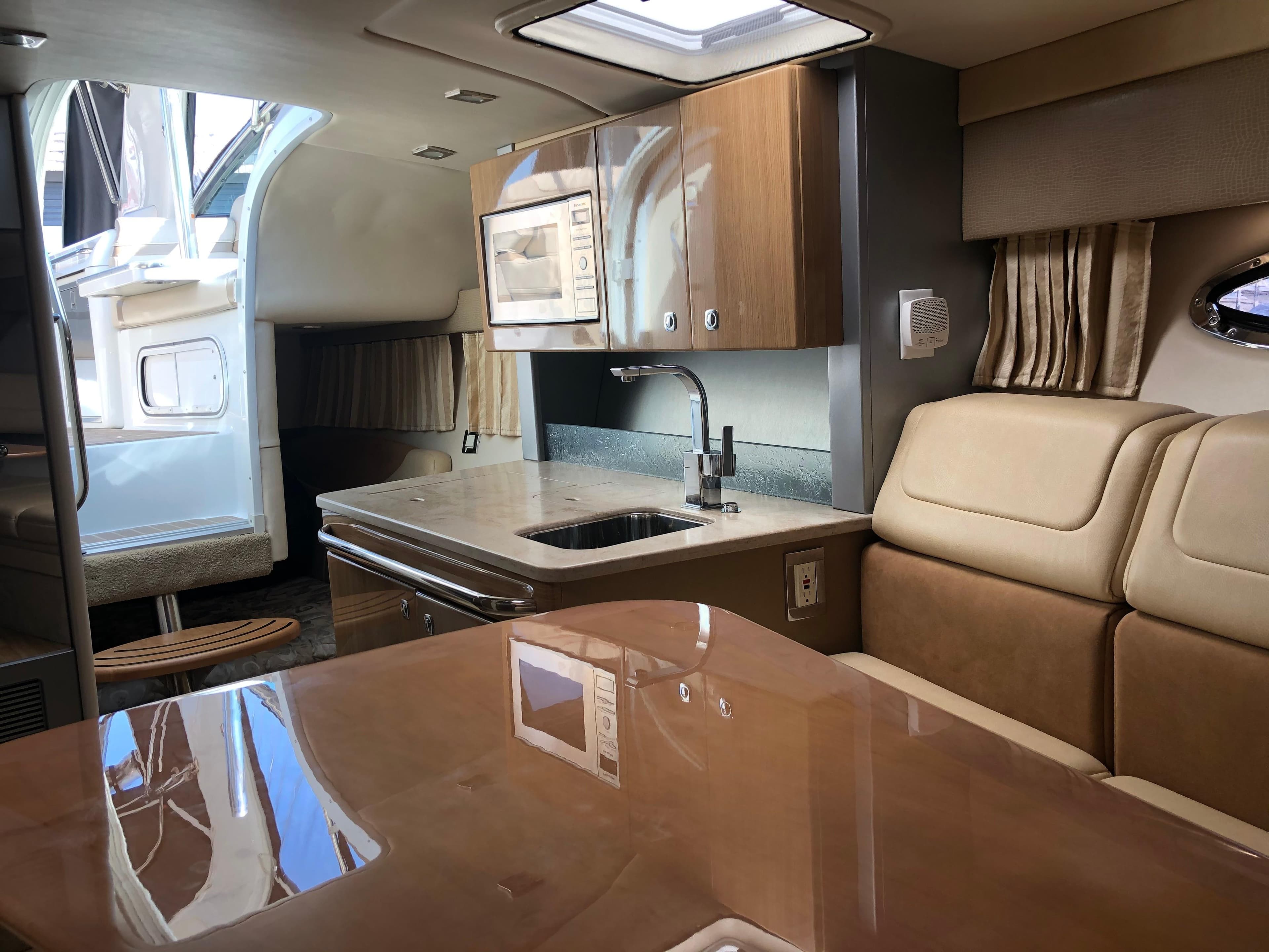 Luxurious interior of a 2013 Formula 350 Sun Sport boat with modern kitchen amenities.
